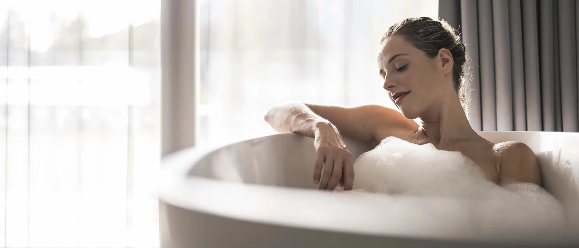 Frau entspannt sich in einer Badewanne mit Schaumbad