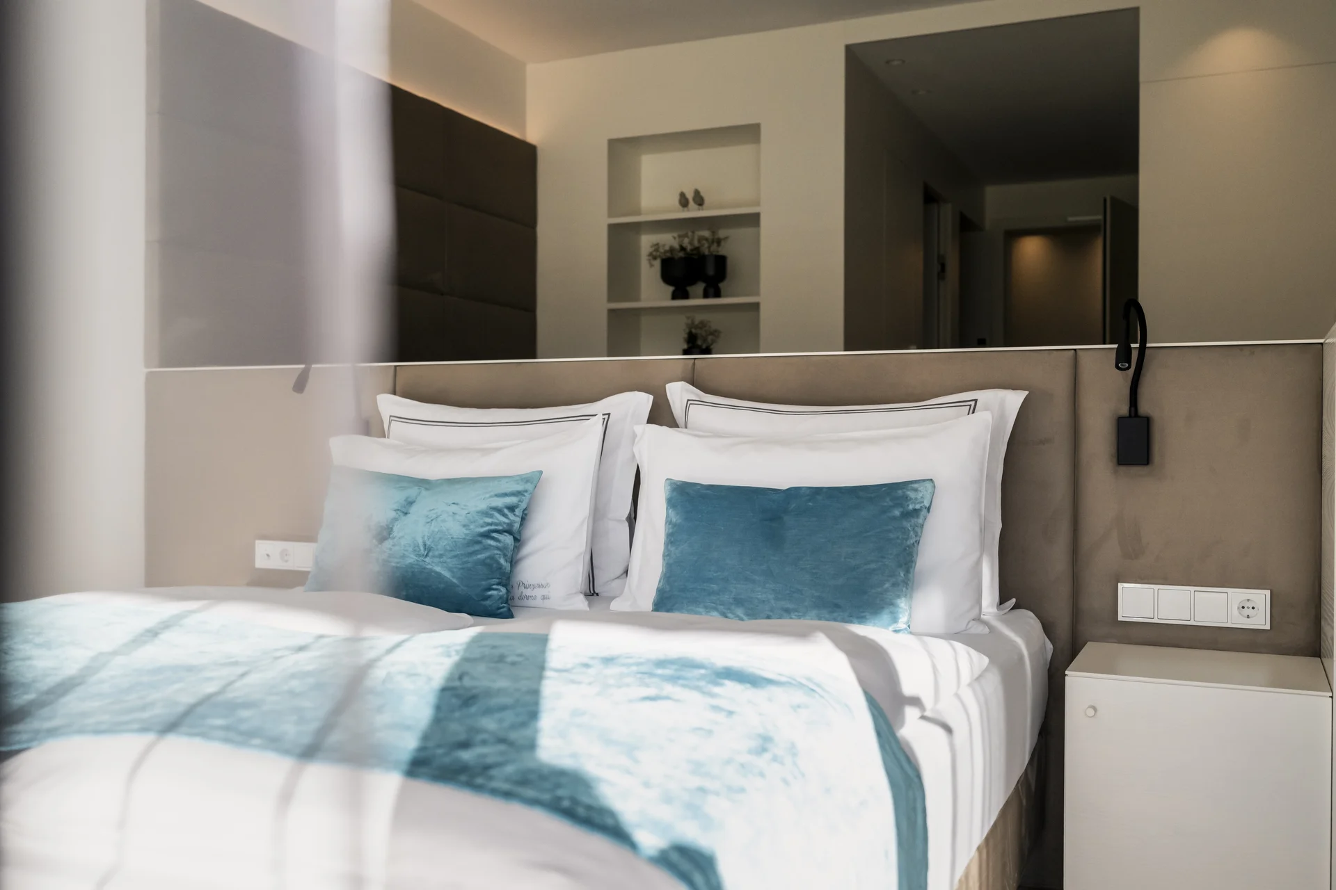 Modernes Schlafzimmer mit weißen und blauen Kissen und Decken