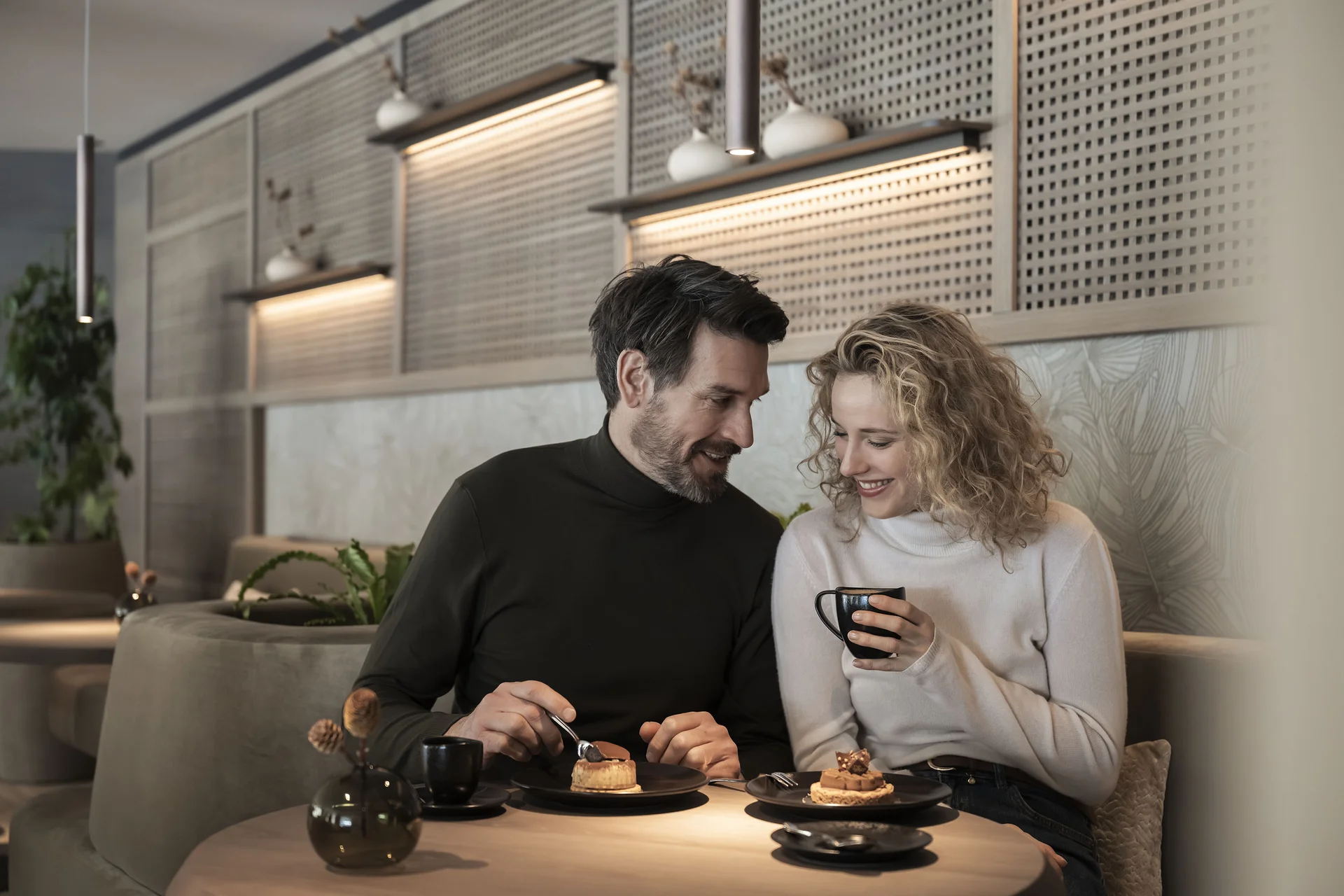 Paar genießt Kaffee und Kuchen in gemütlichem Café
