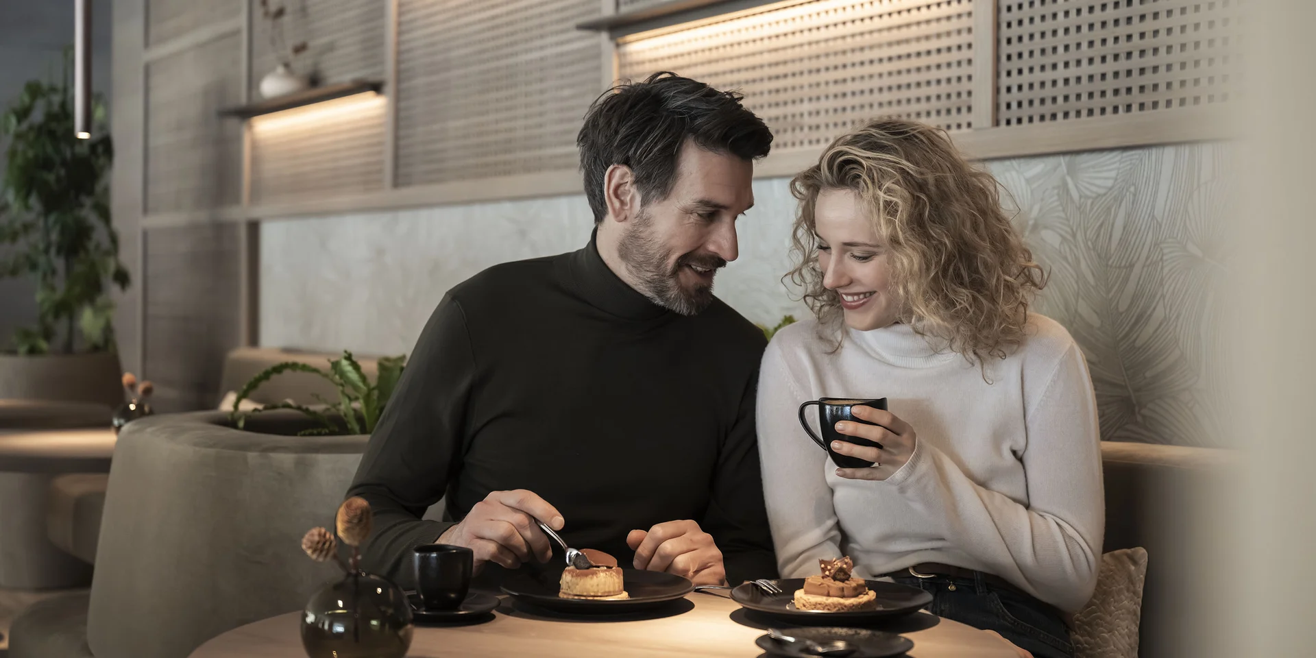 Coppia che gusta caffè e dolci in un accogliente caffè
