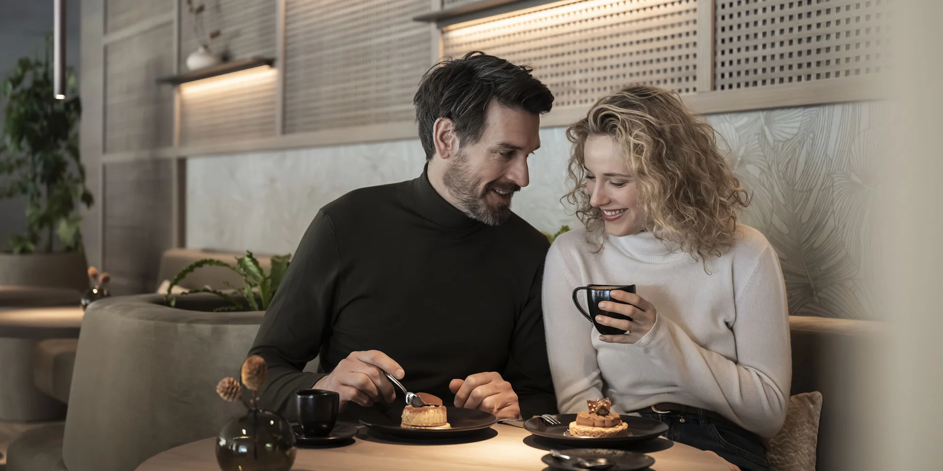 Paar genießt Kaffee und Kuchen in gemütlichem Café