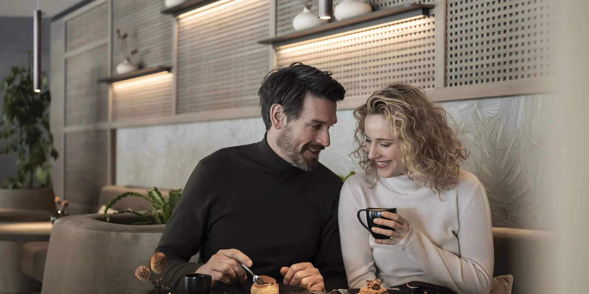 Coppia che gusta caffè e dolci in un accogliente caffè