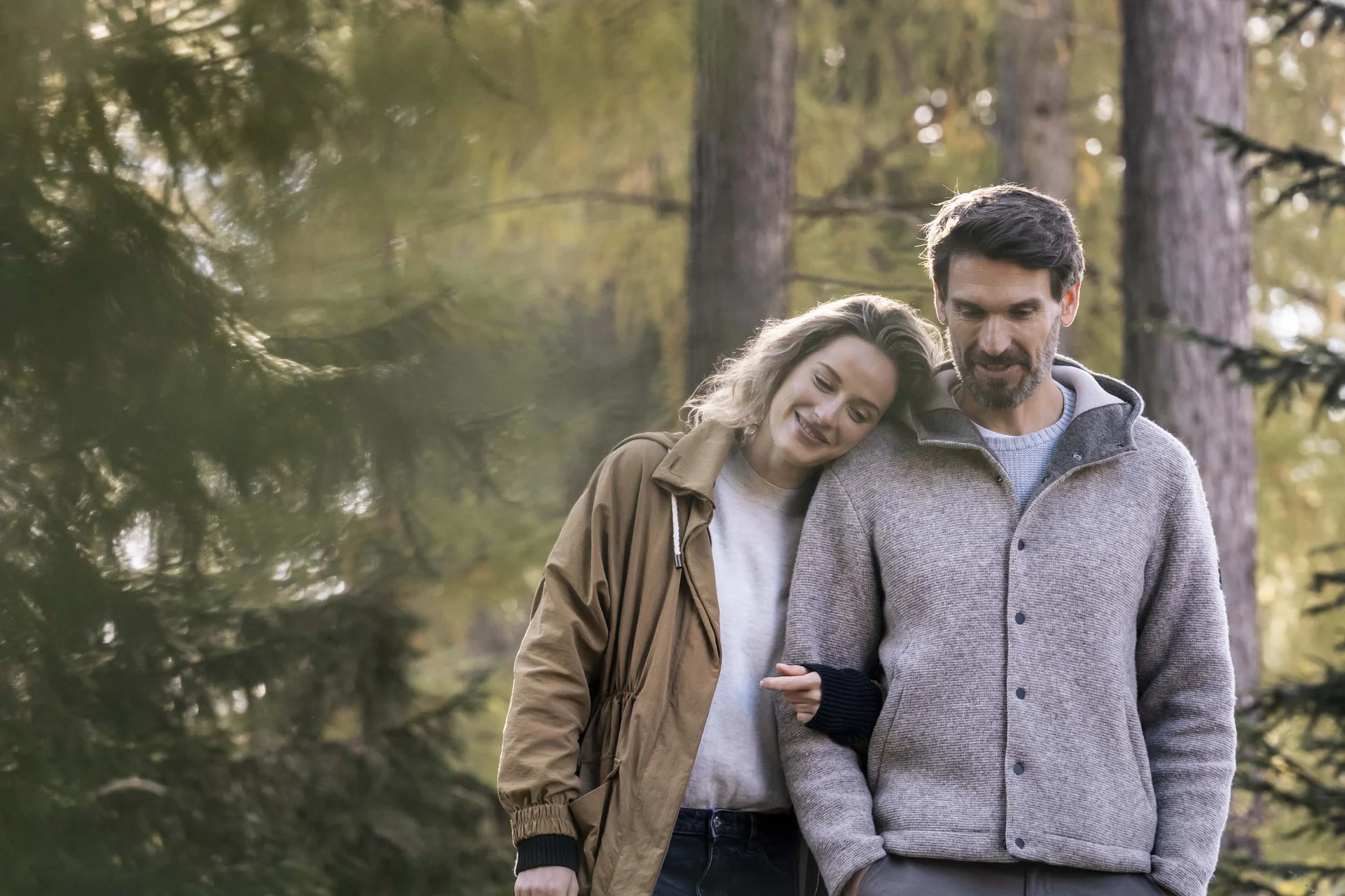 Paar geht gemütlich im herbstlichen Wald spazieren