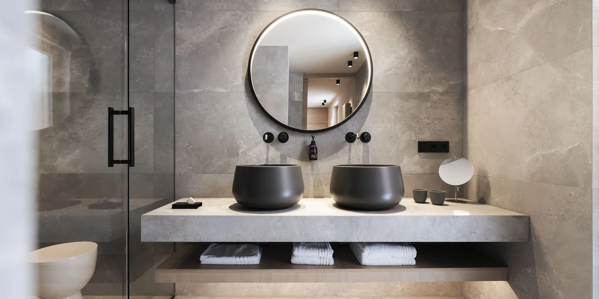 Bagno moderno con due lavandini neri e specchio ovale