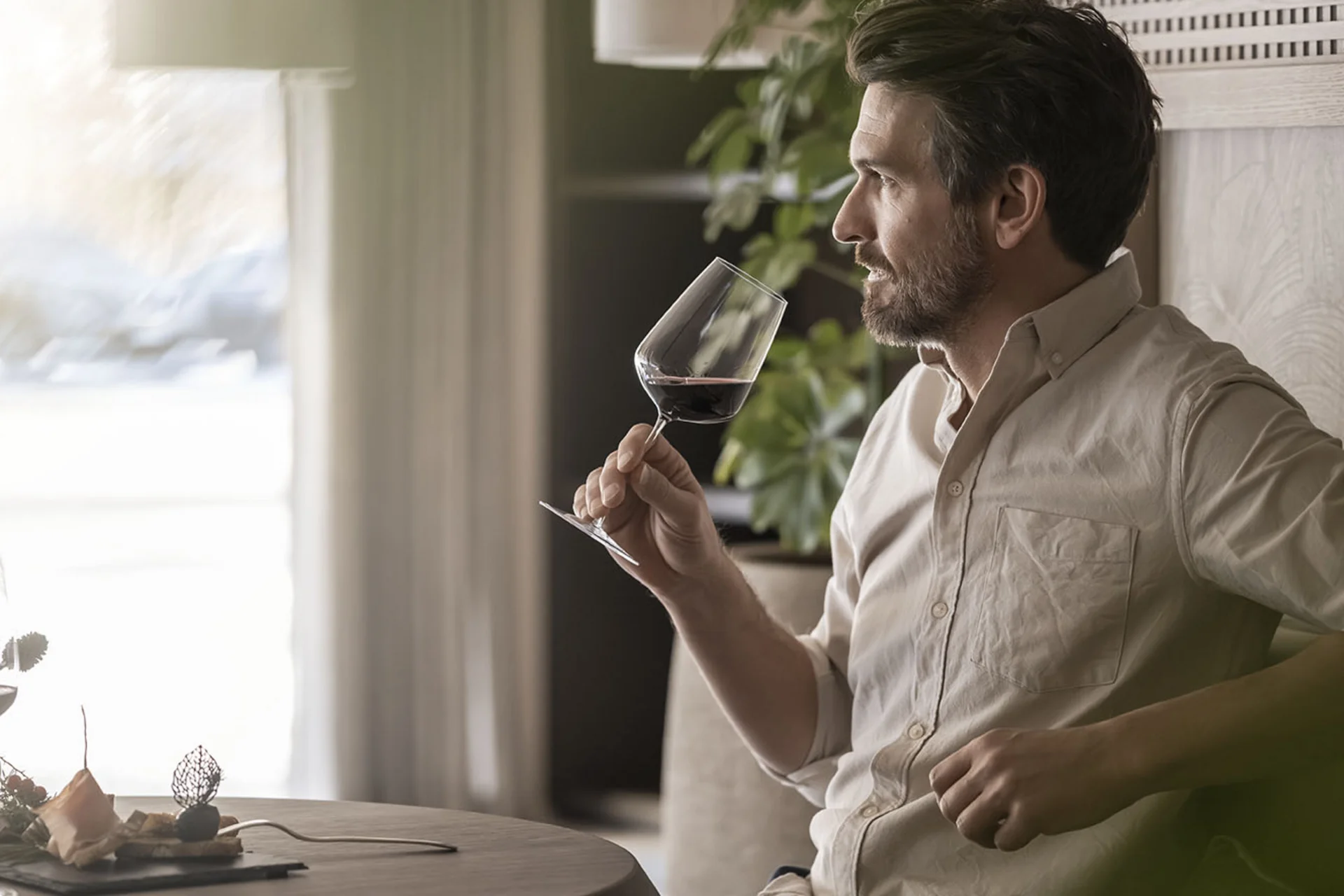 Man enjoying a glass of red wine in a modern setting