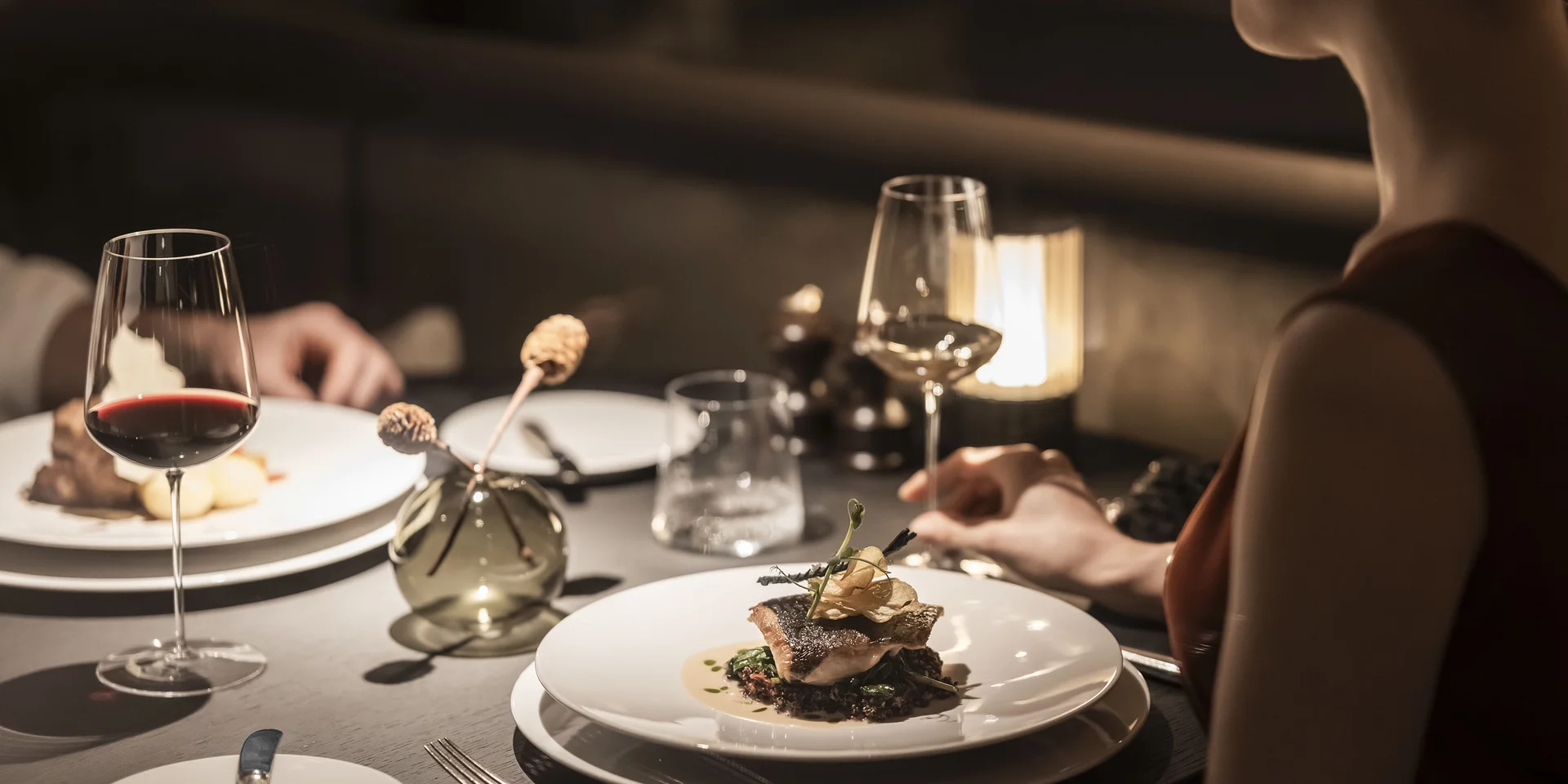 Cena elegante con piatti gourmet e bicchieri di vino in ristorante