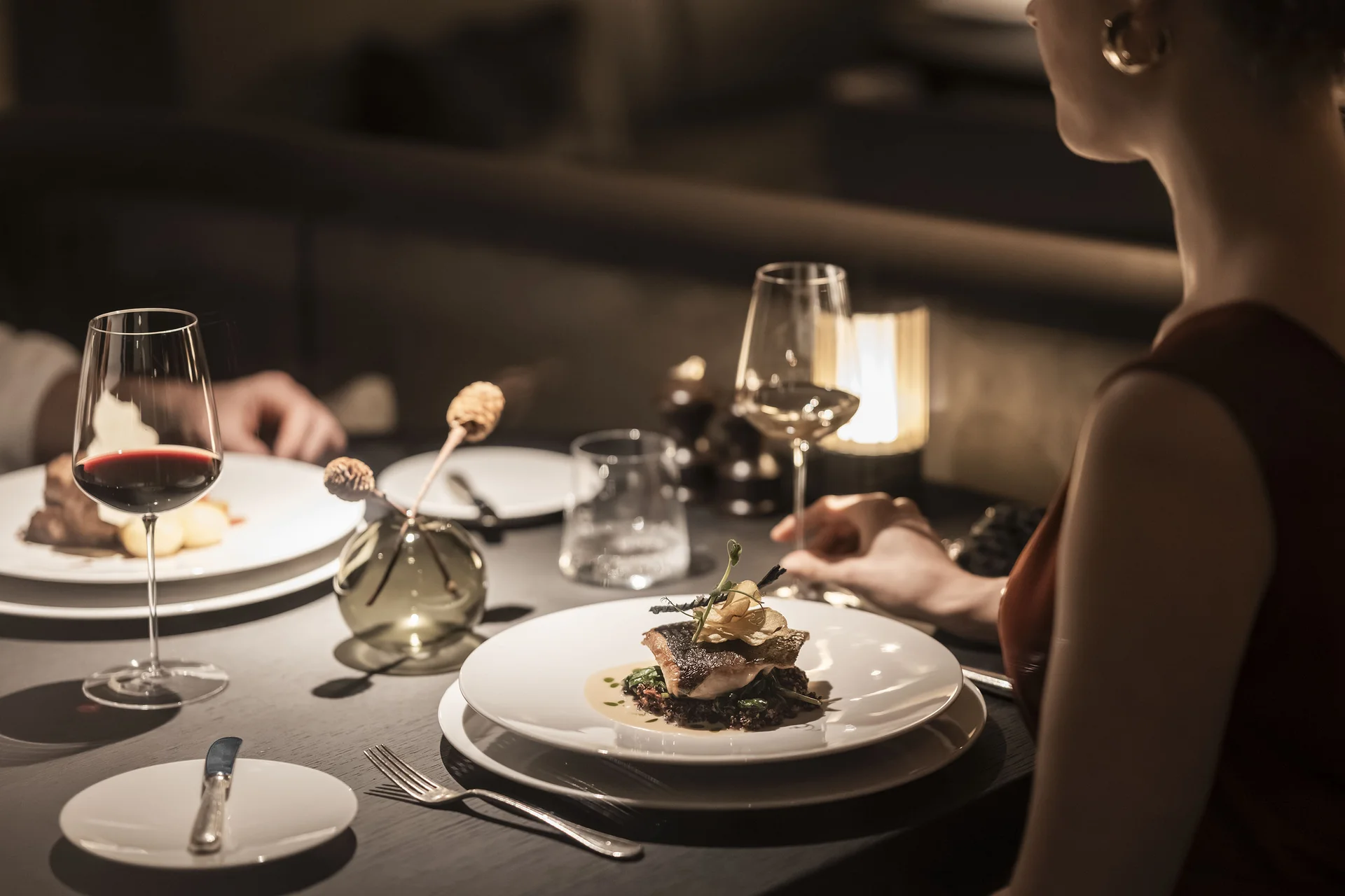 Cena elegante con piatti gourmet e bicchieri di vino in ristorante