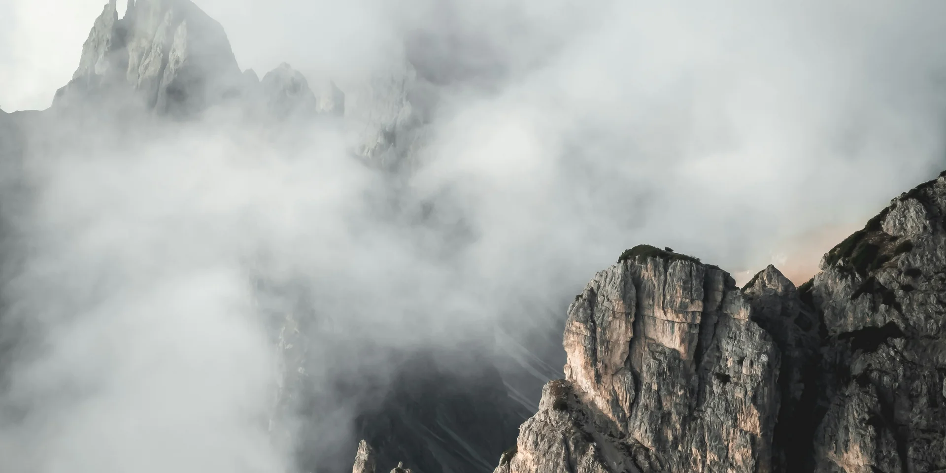 Felsige Bergspitzen umgeben von dichtem Nebel