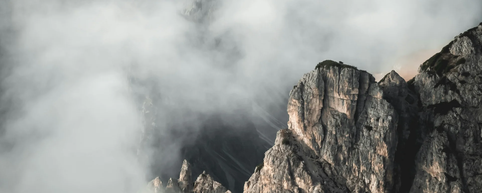 Fitness, Yoga, Outdoor-Erlebnisse: Aktivhotel in Südtirol Felsige Bergspitzen umgeben von dichtem Nebel