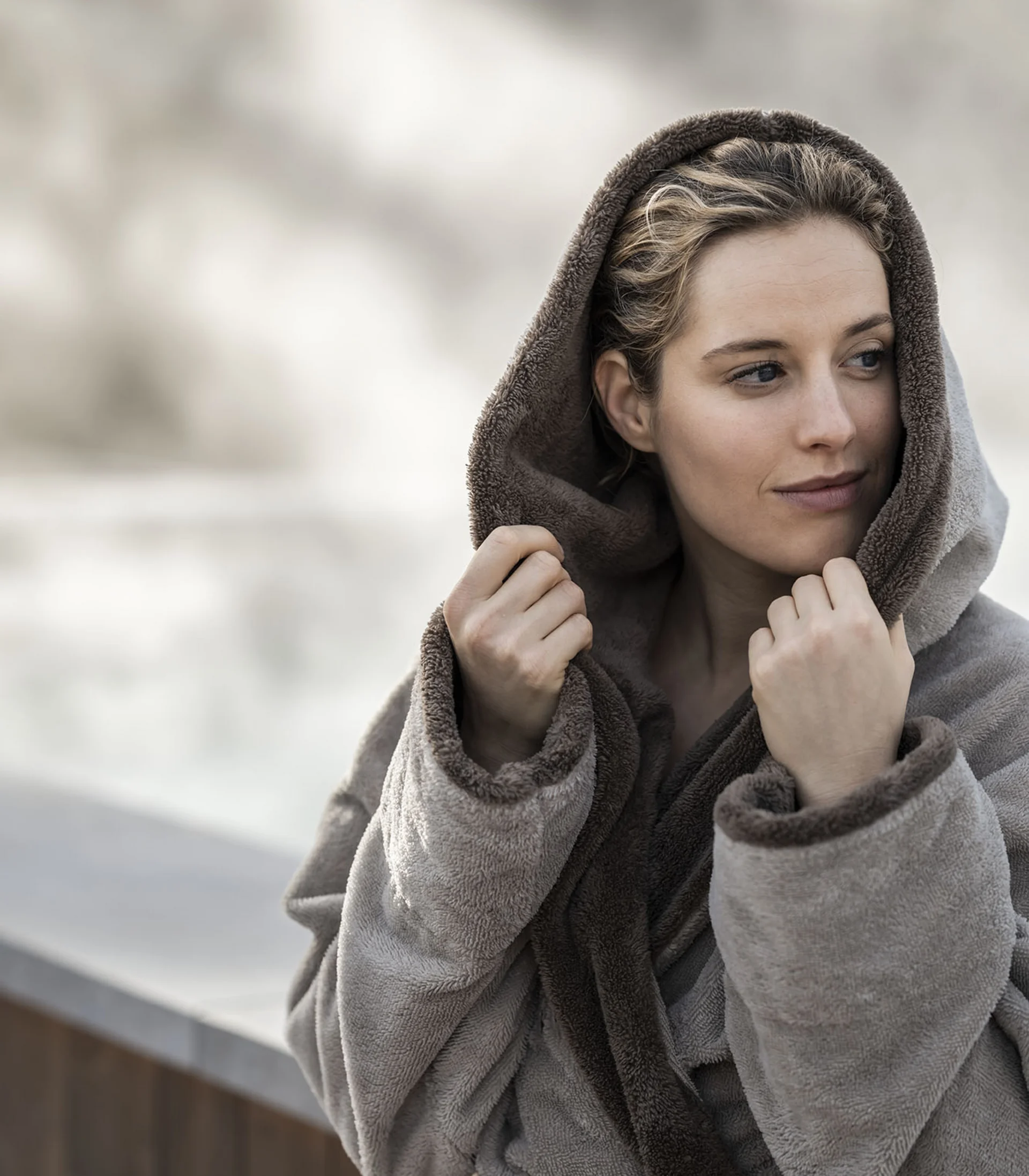 Donna con accappatoio caldo che si copre con il cappuccio al freddo