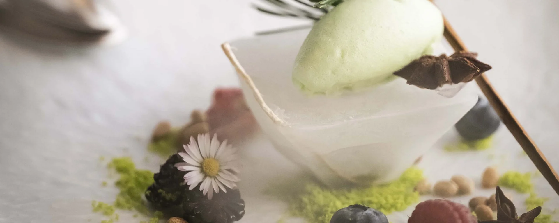 Café the bosco®: ein Ort des Genusses und der Begegnung Feines Dessert mit Beeren, Eis und Gewürzen auf weißem Teller