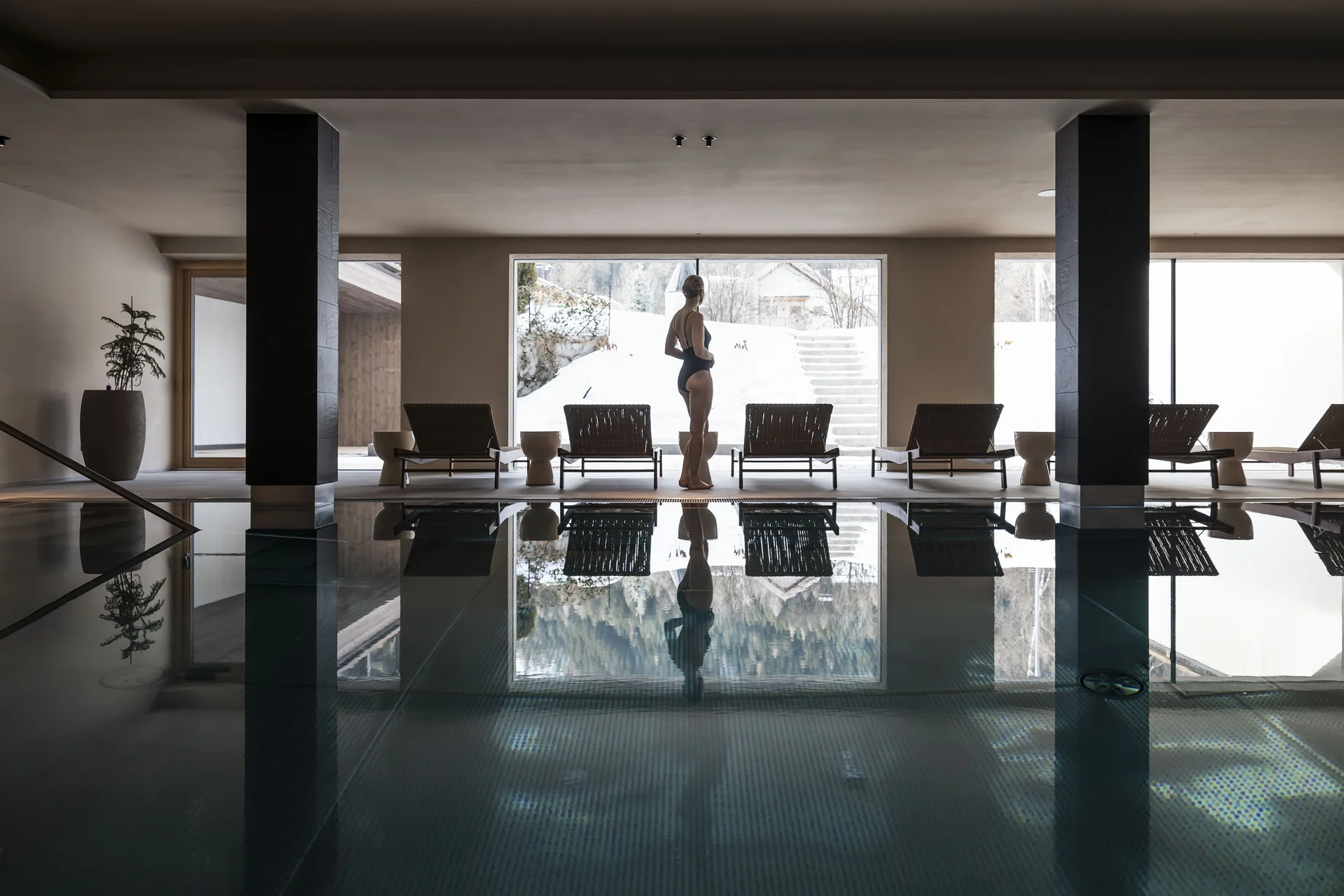 Frau am Innenpool mit Schneelandschaft draußen