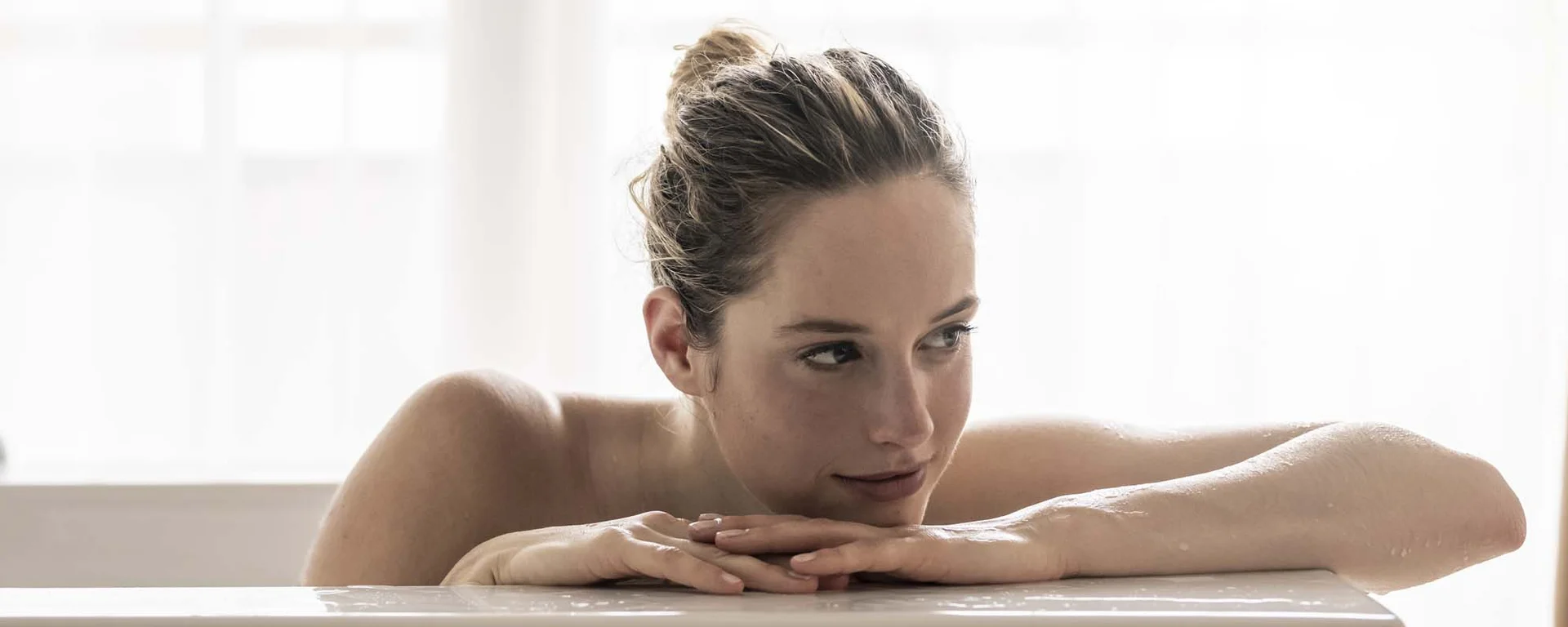 Hotel Monika: Ihr Adults-only-Wellnesshotel in Südtirol Frau entspannt in der Badewanne vor hellem Fenster