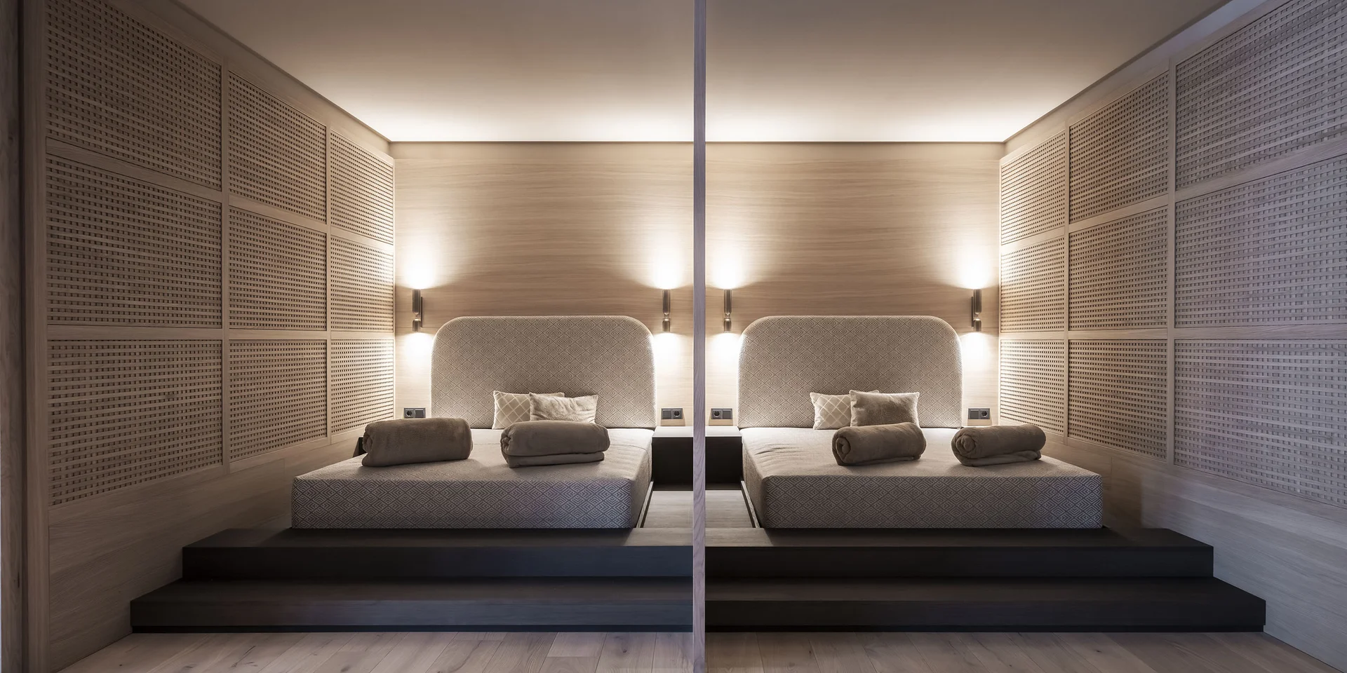 Camera moderna con due letti singoli e luci da parete calde