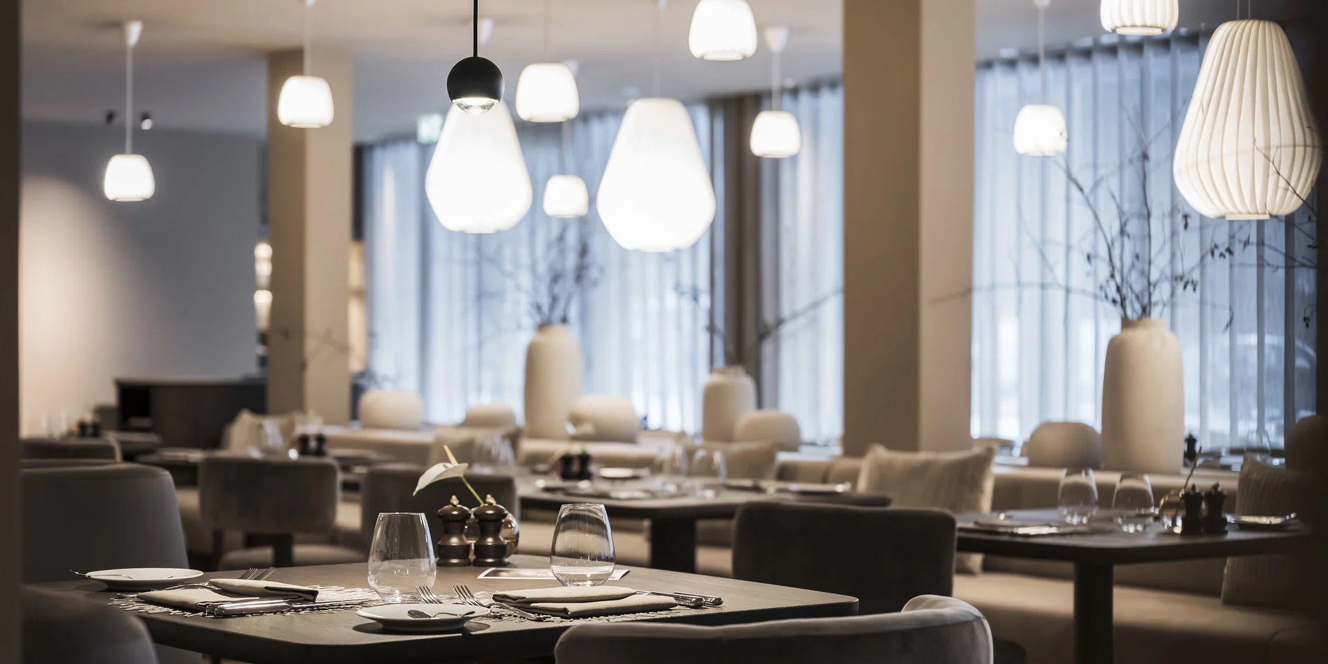 Ristorante moderno con tavoli apparecchiati e lampade a sospensione eleganti