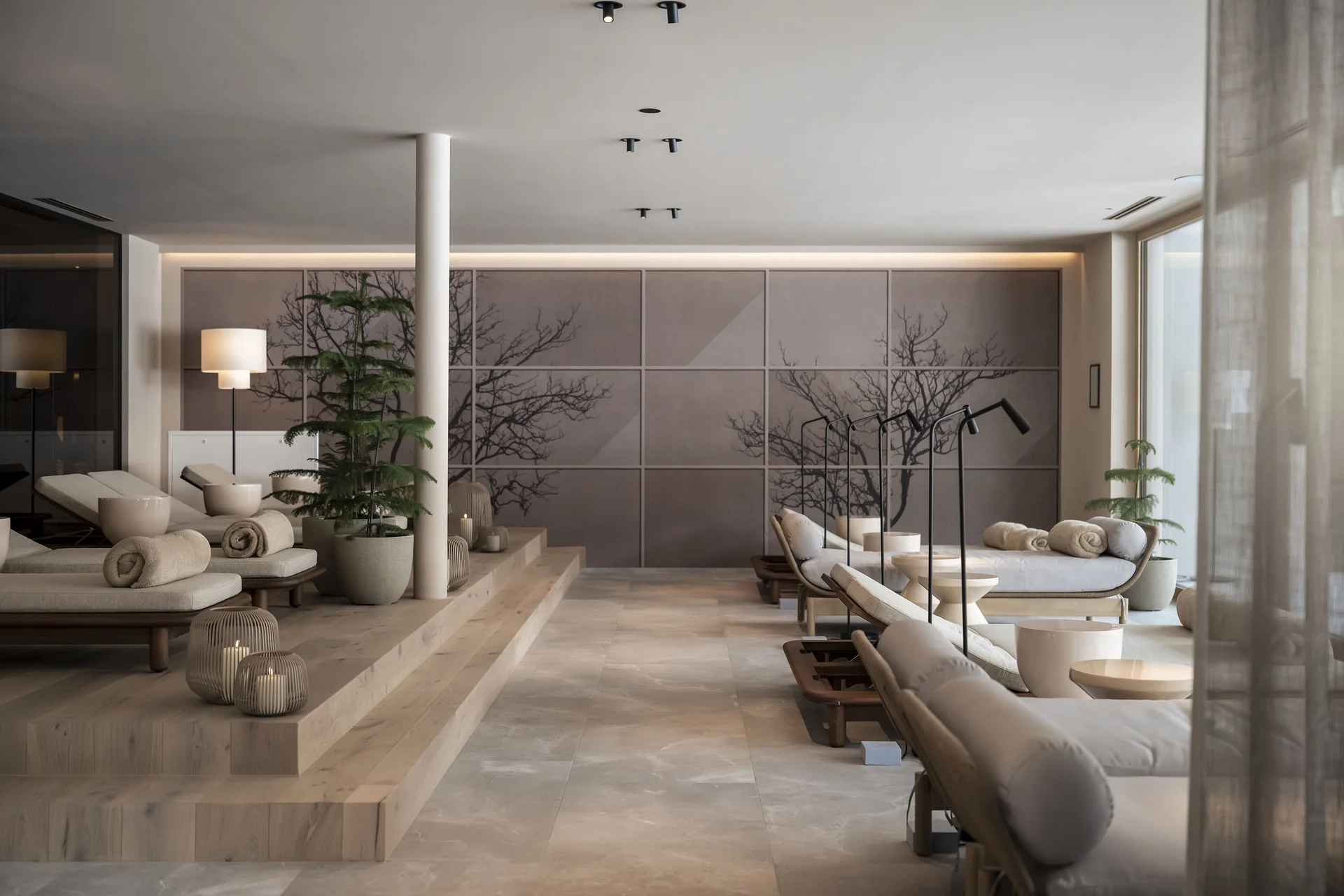 Area benessere moderna con lettini, piante e candele