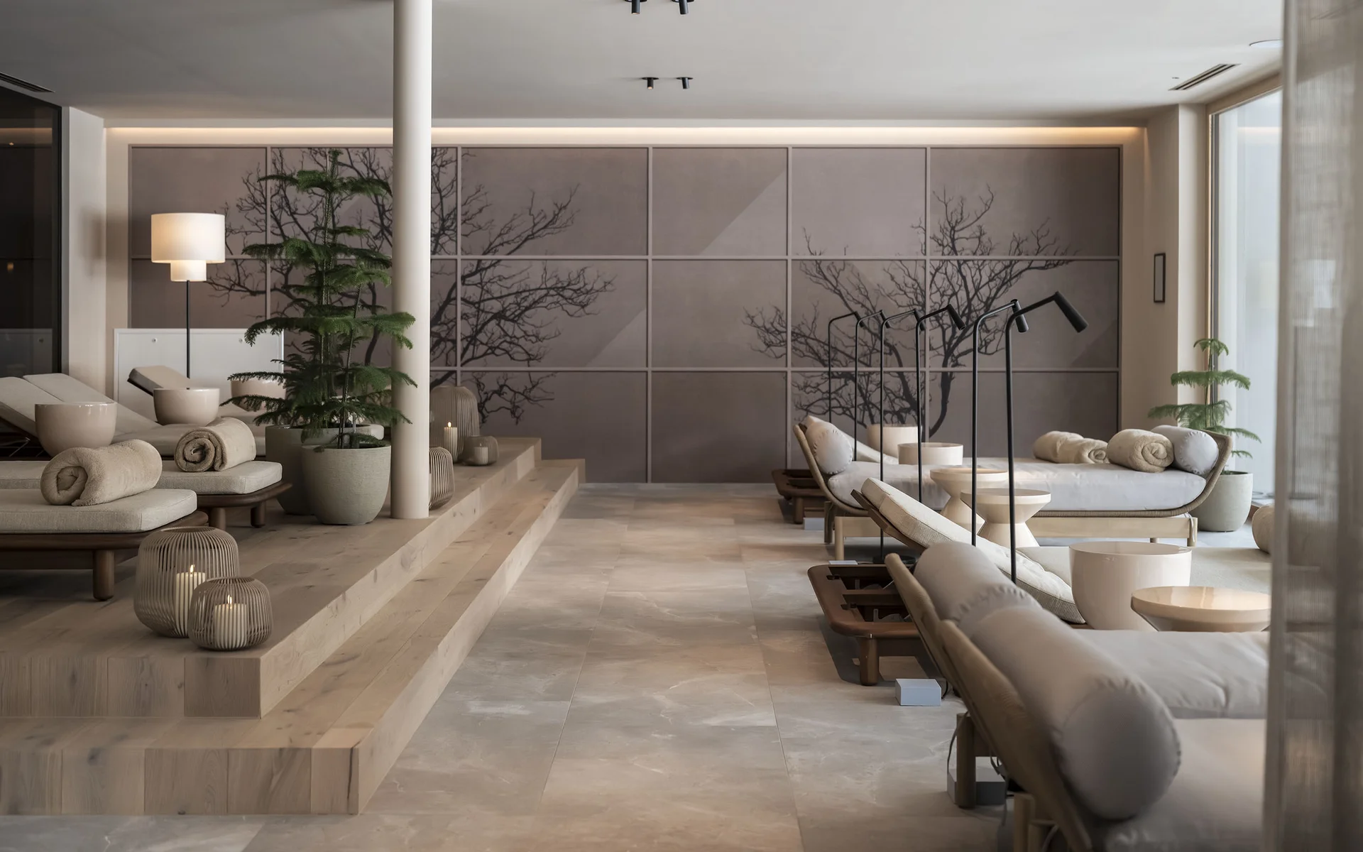 Area benessere moderna con lettini, piante e candele