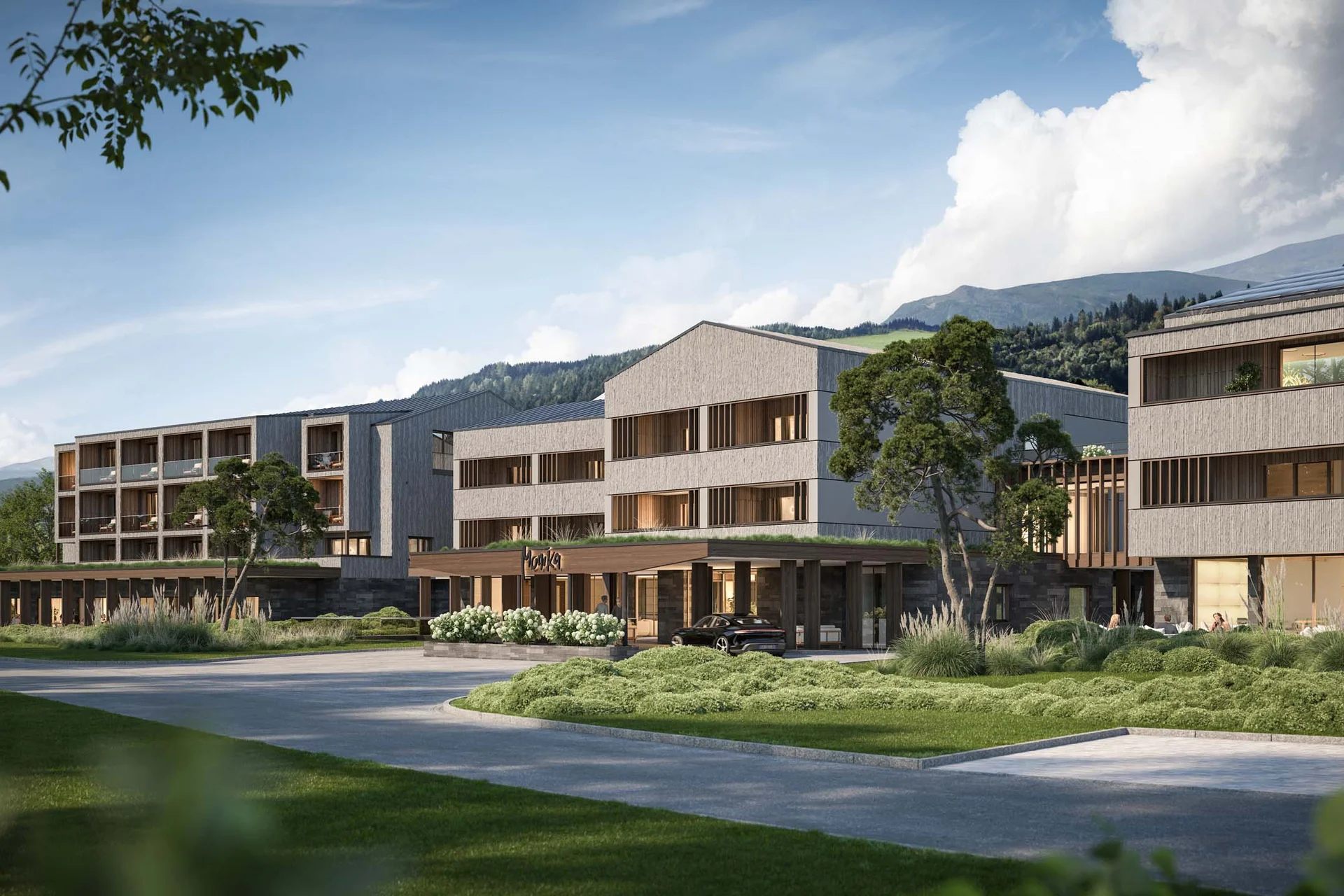 Modernes Hotelgebäude umgeben von Grünflächen und Bergen im Hintergrund