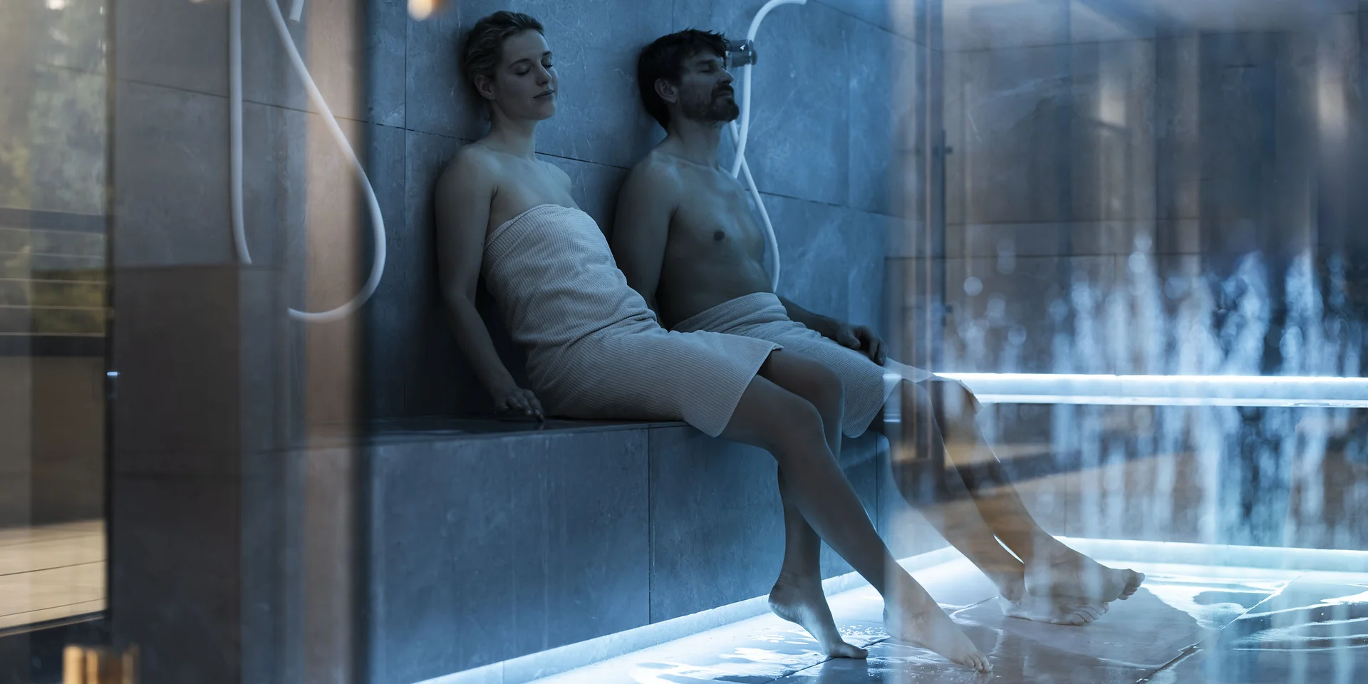 Coppia rilassata in un bagno turco moderno con asciugamani