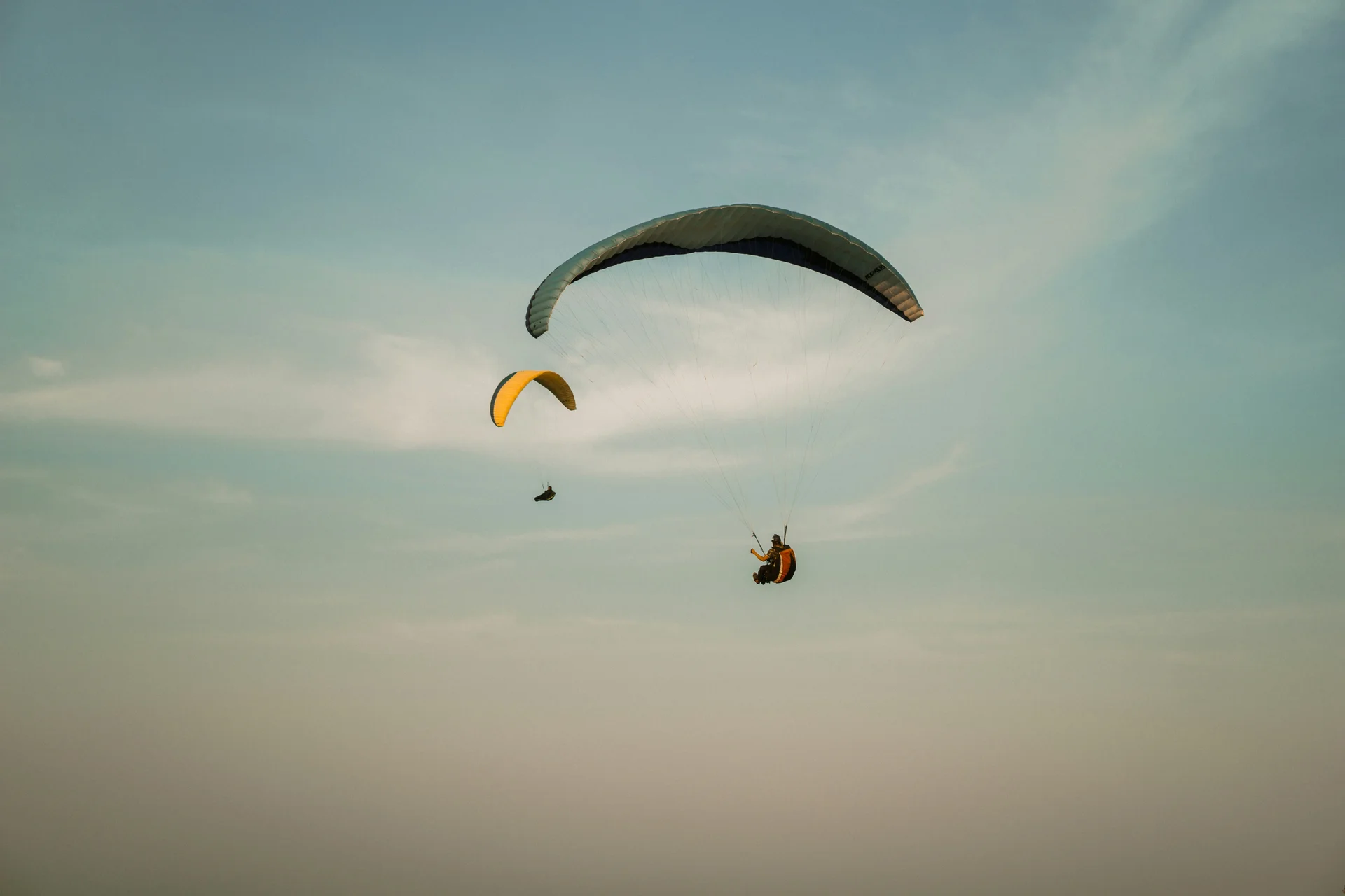 Due parapendii che volano nel cielo al tramonto.
