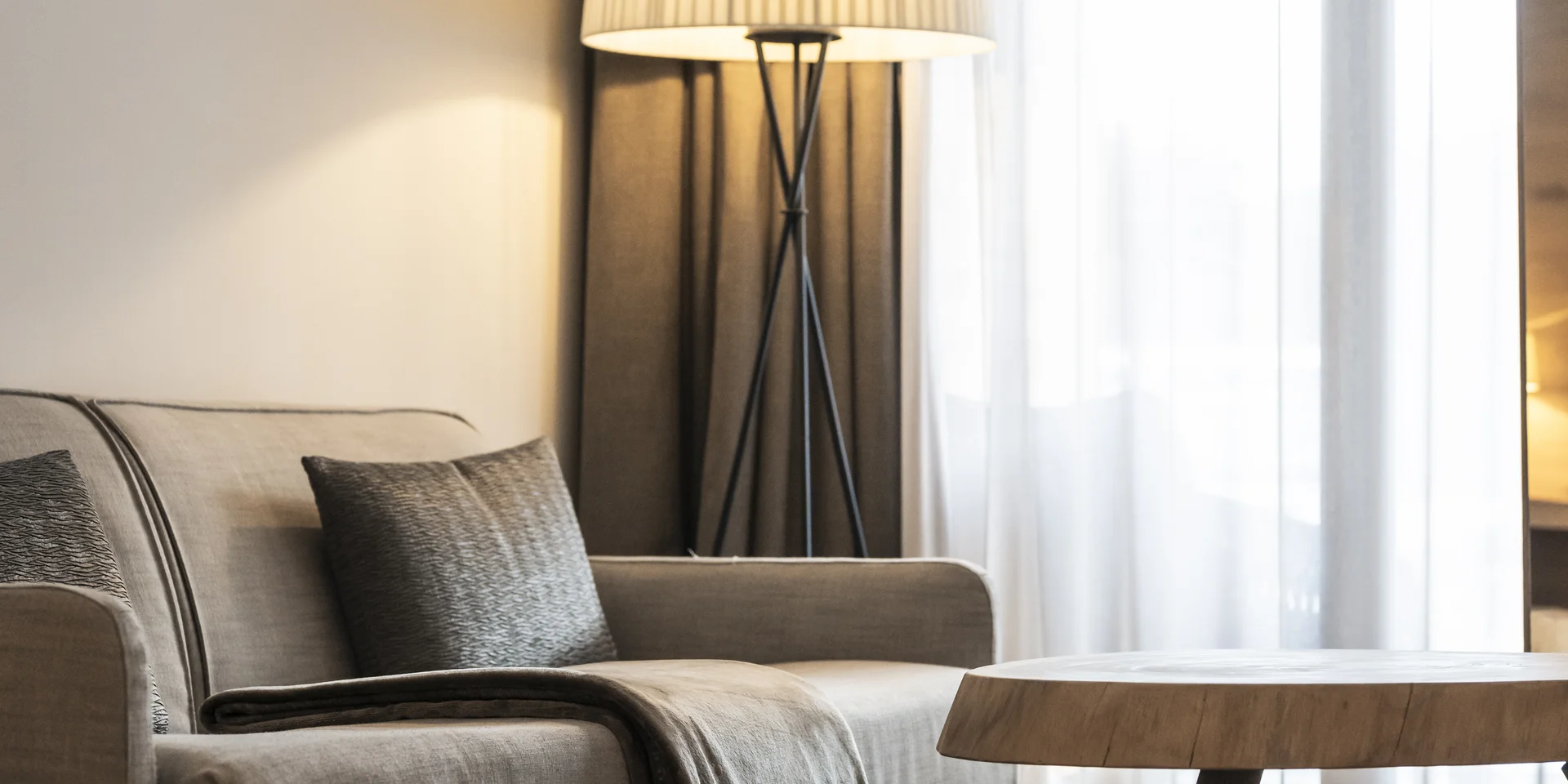 Modern living room with sofa, floor lamp, and round wooden coffee table