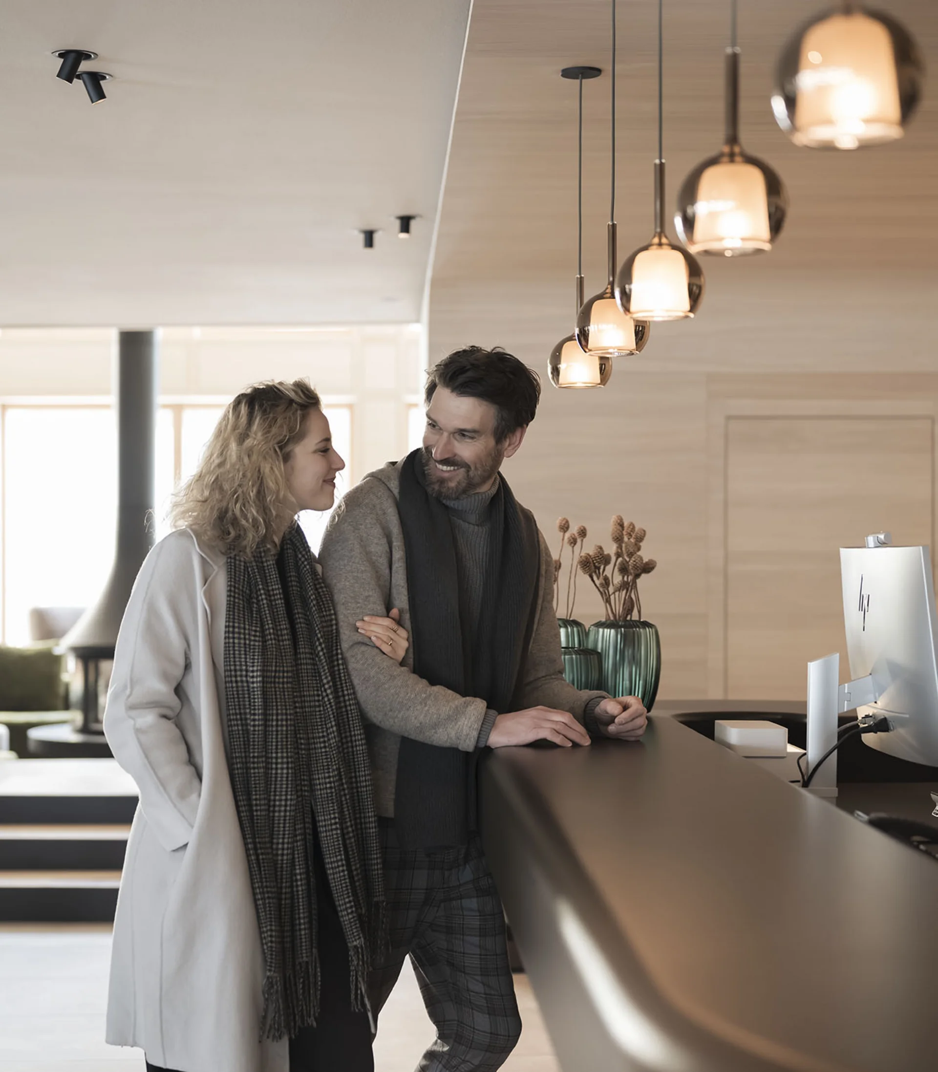 Coppia alla reception di un hotel moderno, amichevole e rilassata