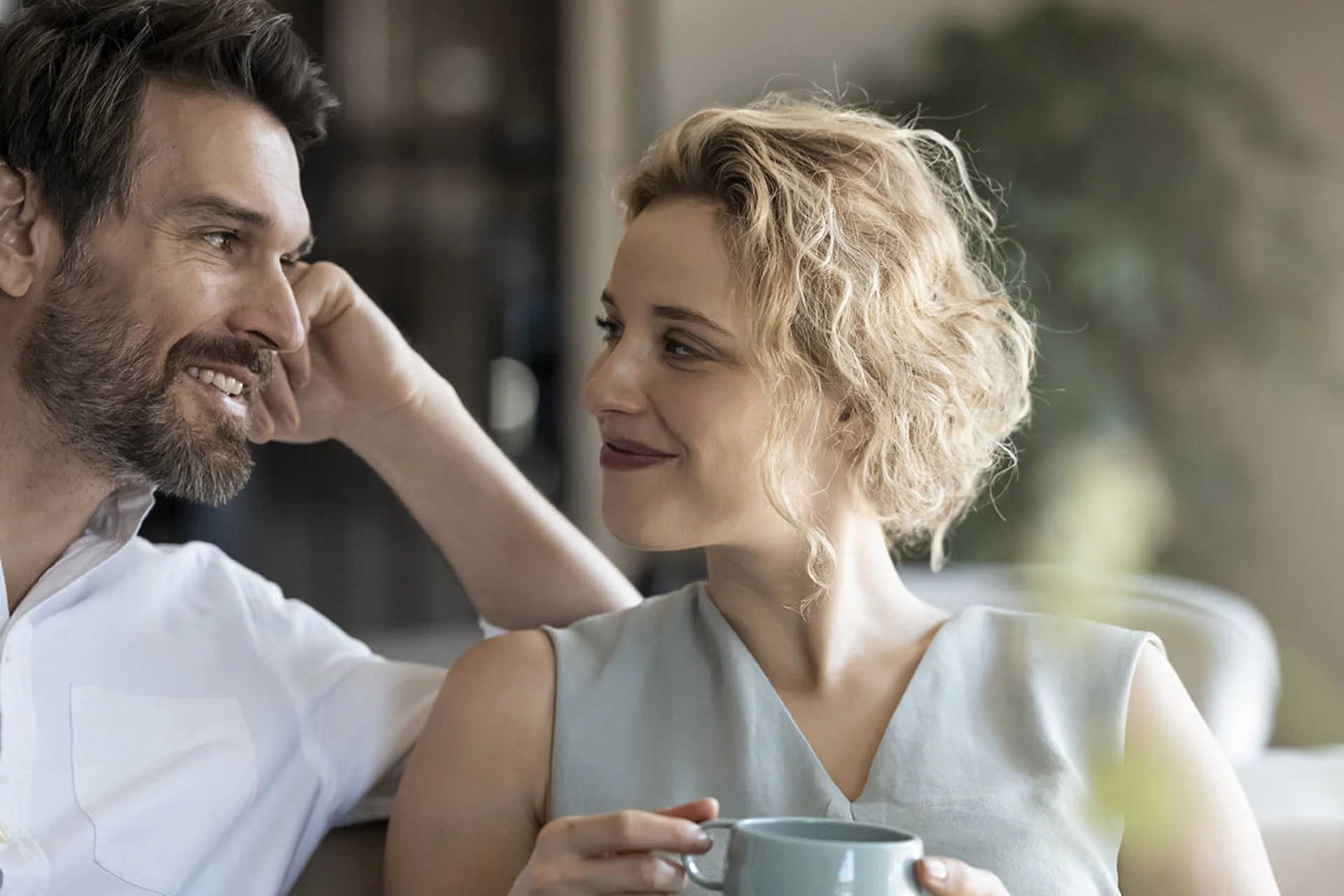 Couple relaxing on sofa enjoying coffee together