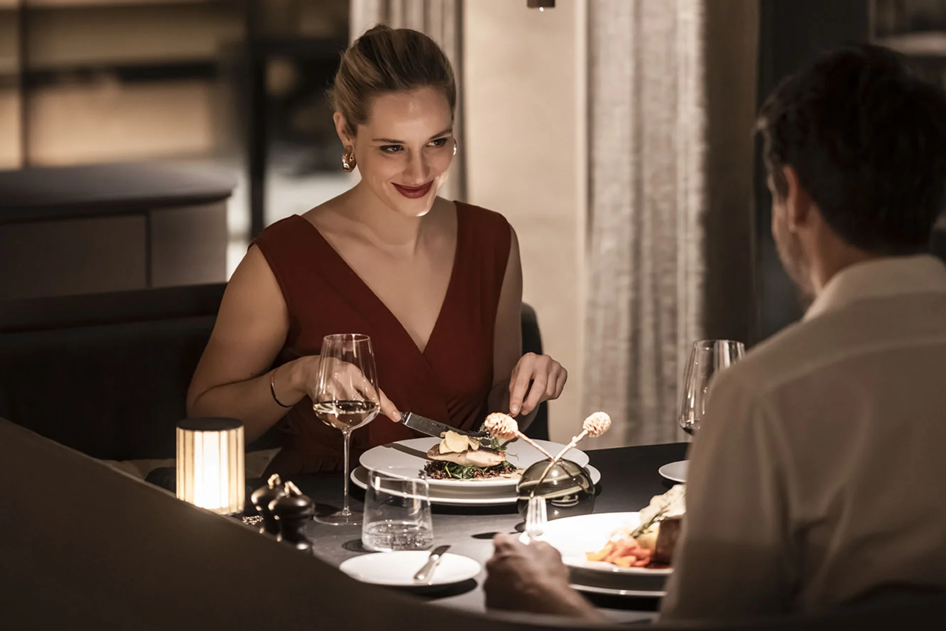 Coppia che cena in un ristorante elegante con illuminazione soffusa