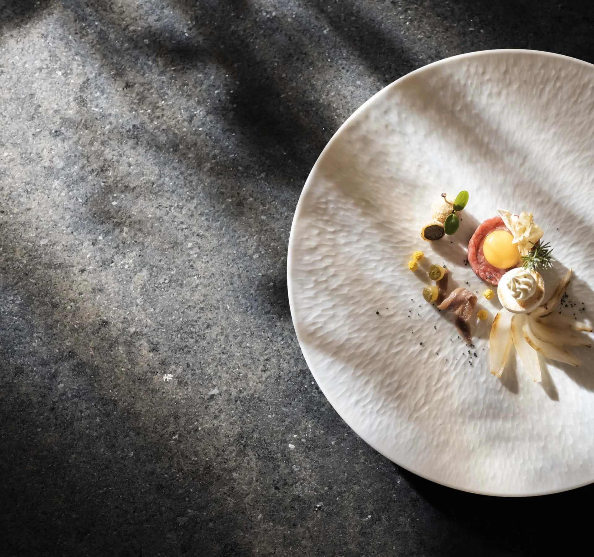 Artfully plated dish on a white plate with dark background