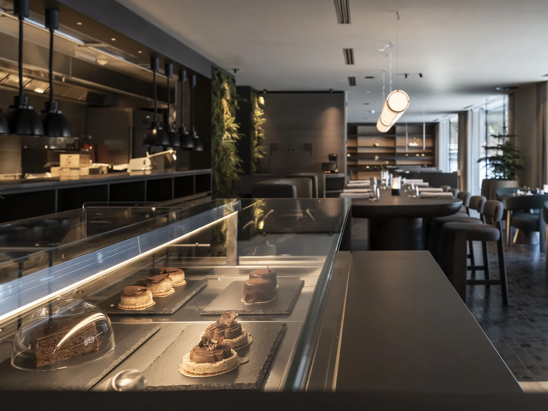 Modern café interior with dessert display case and seating area