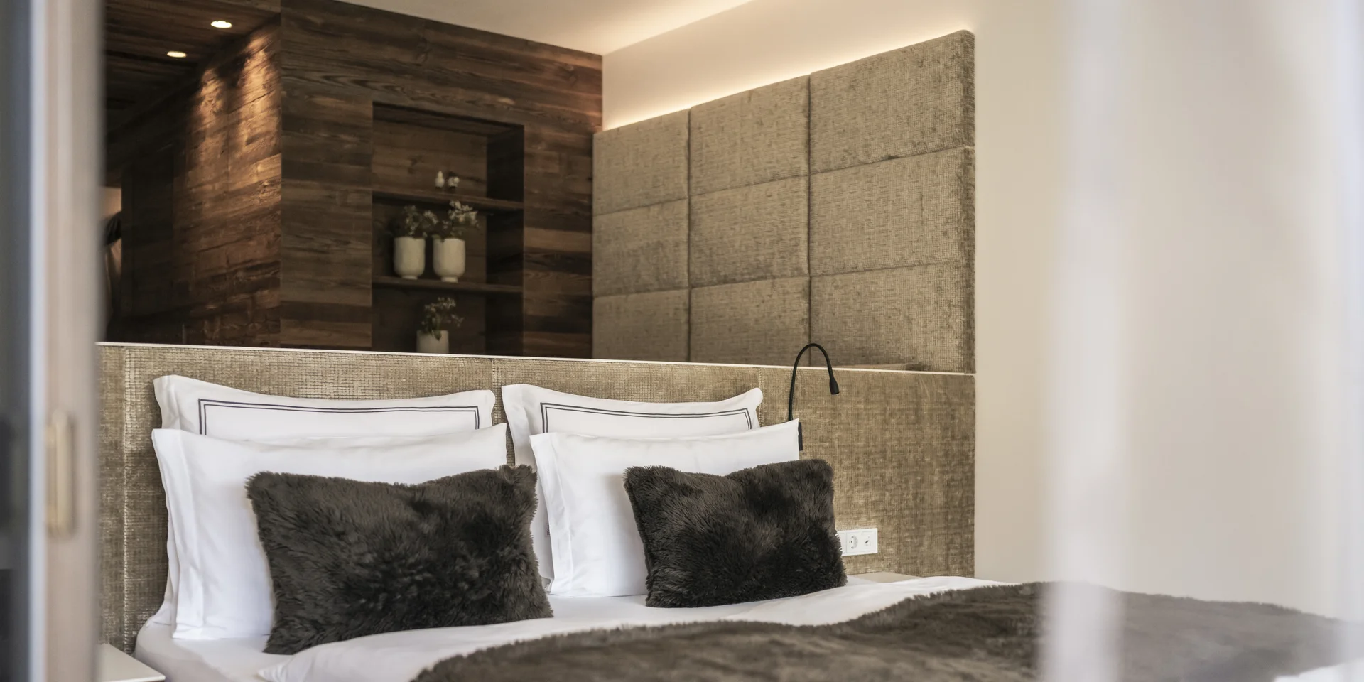 Modernes Schlafzimmer mit rustikalen Holzelementen und weichem Fellbettdecke