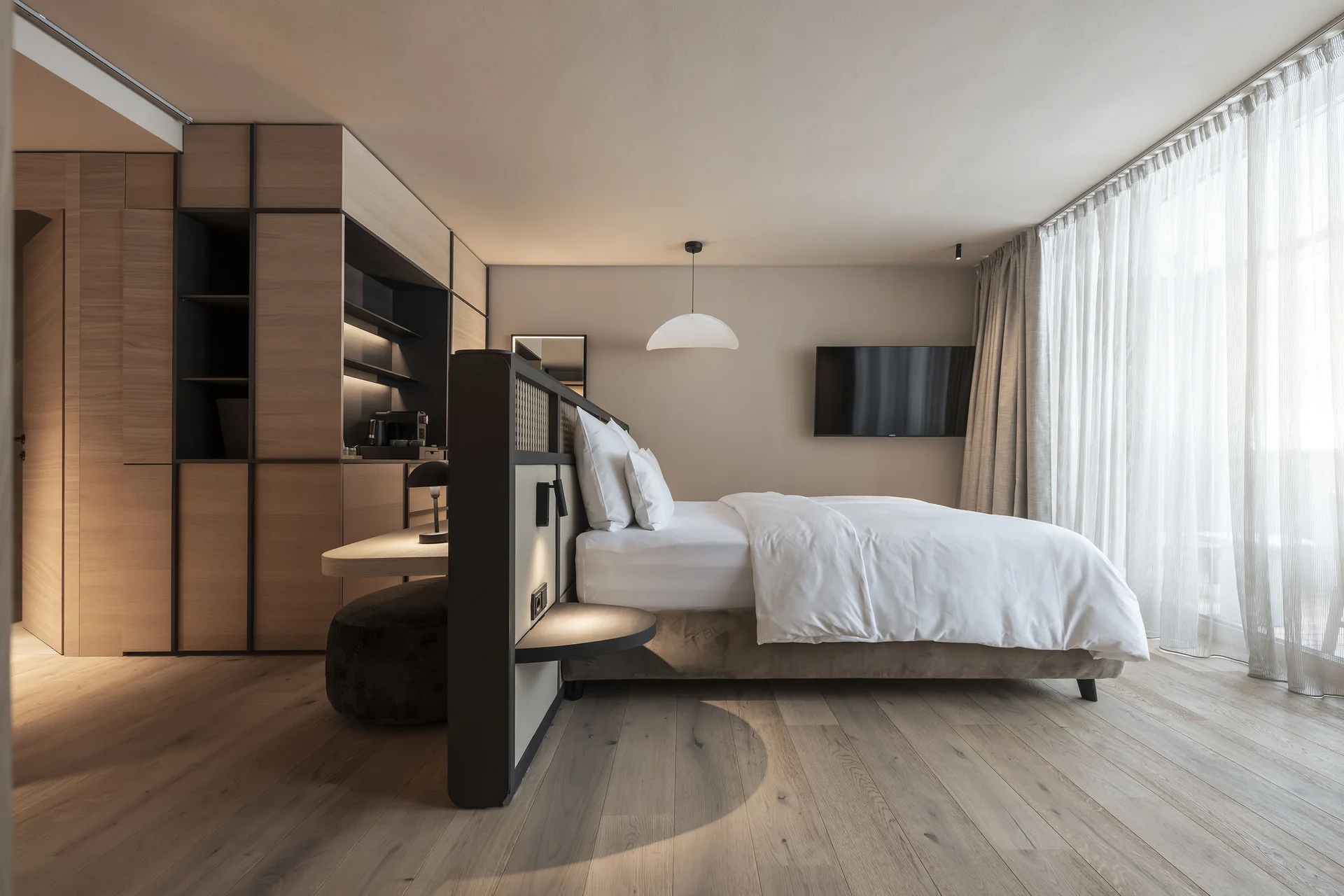 Modernes Hotelzimmer mit großem Bett und bodentiefen Fenstern