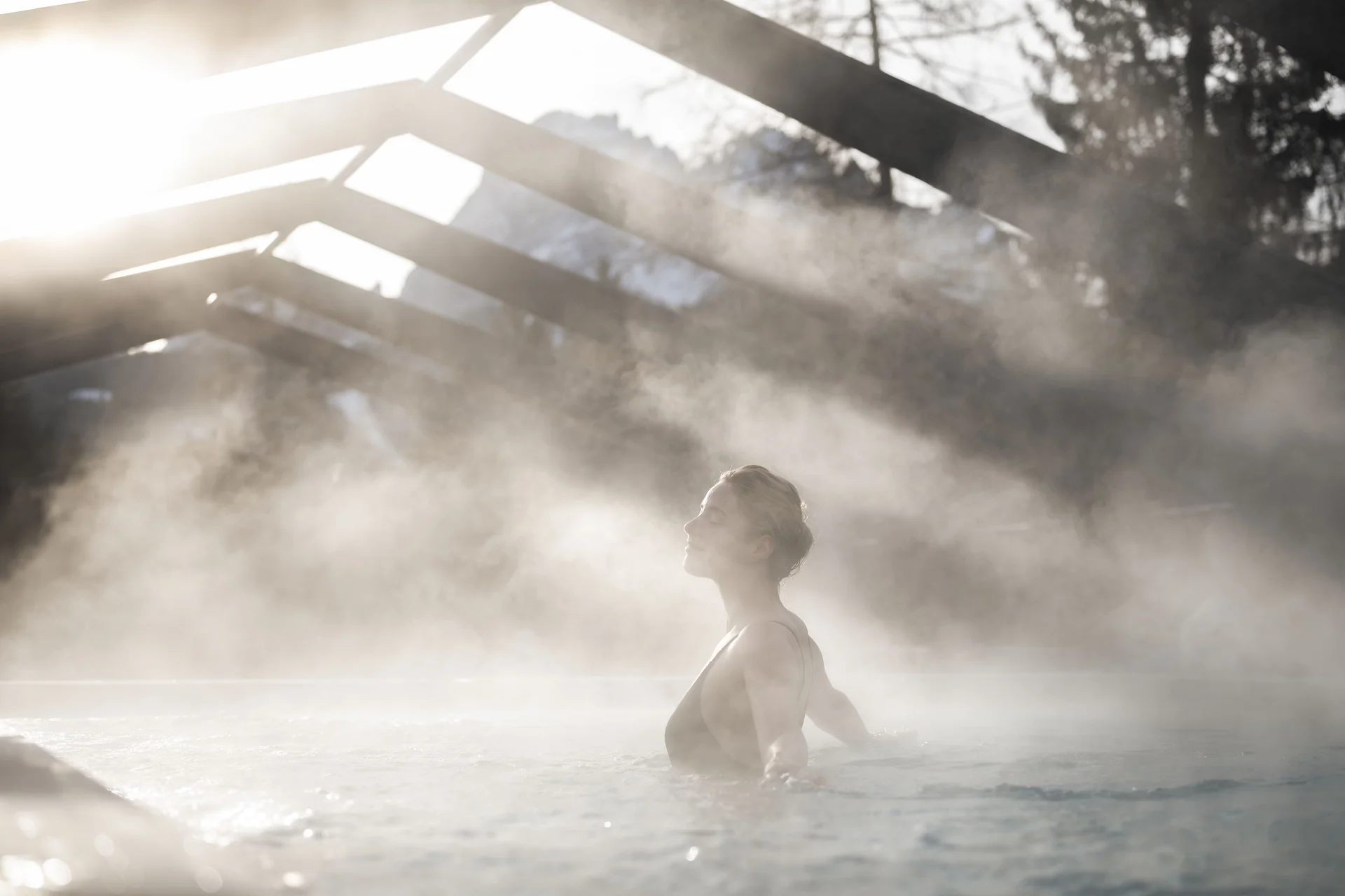 Persona che si rilassa in piscina esterna fumante alla luce del sole