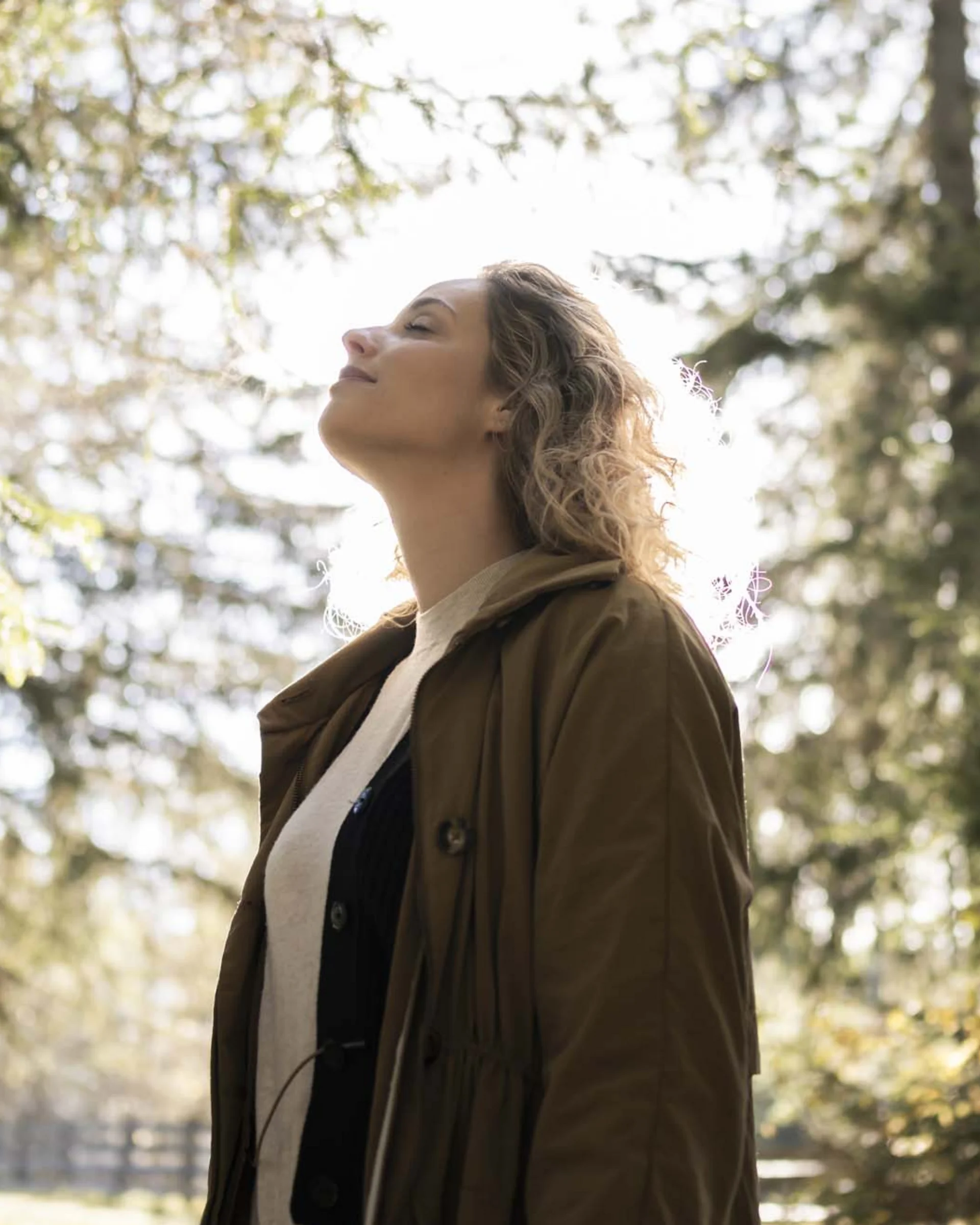 Frau genießt die Natur im Wald bei Sonnenlicht