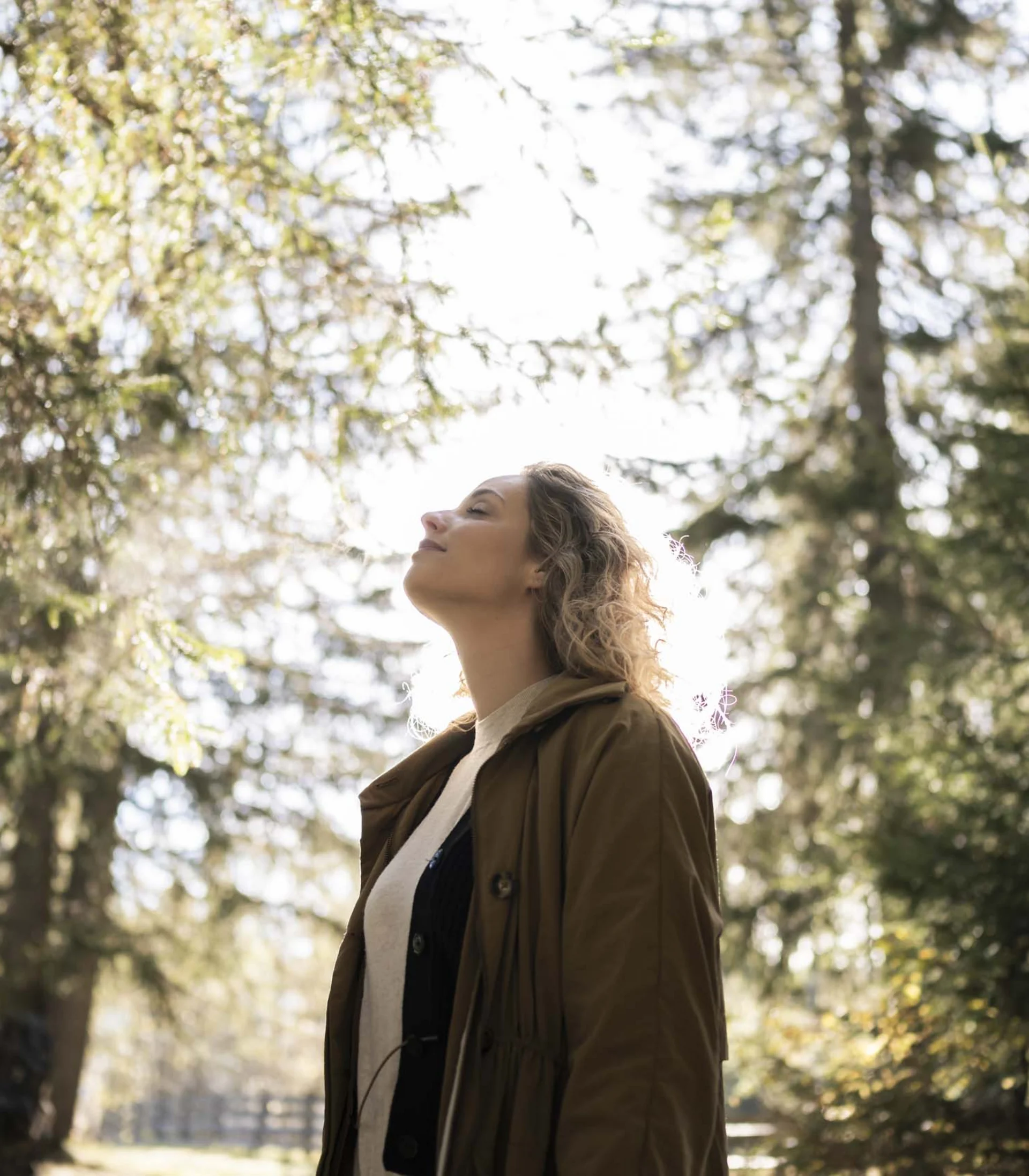 Frau genießt die Natur im Wald bei Sonnenlicht