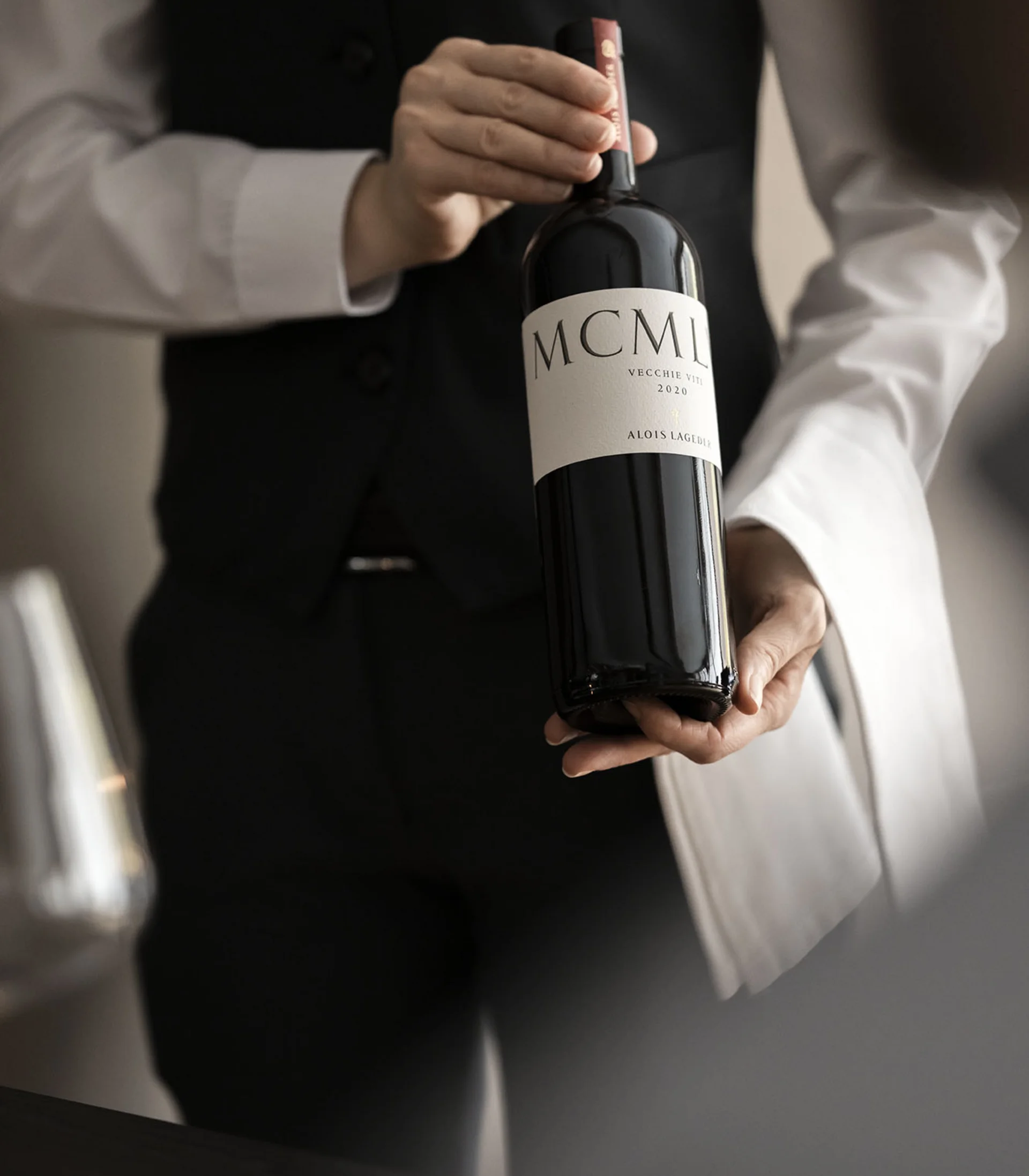Cameriere che presenta una bottiglia di vino MCML