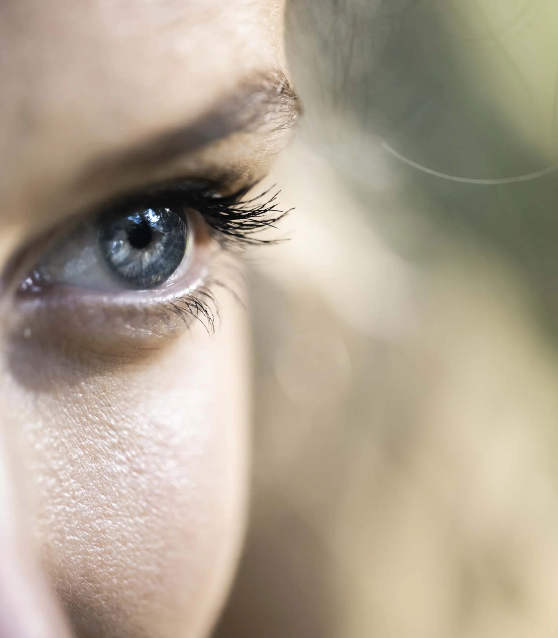 Nahaufnahme eines blauen Auges mit langen Wimpern