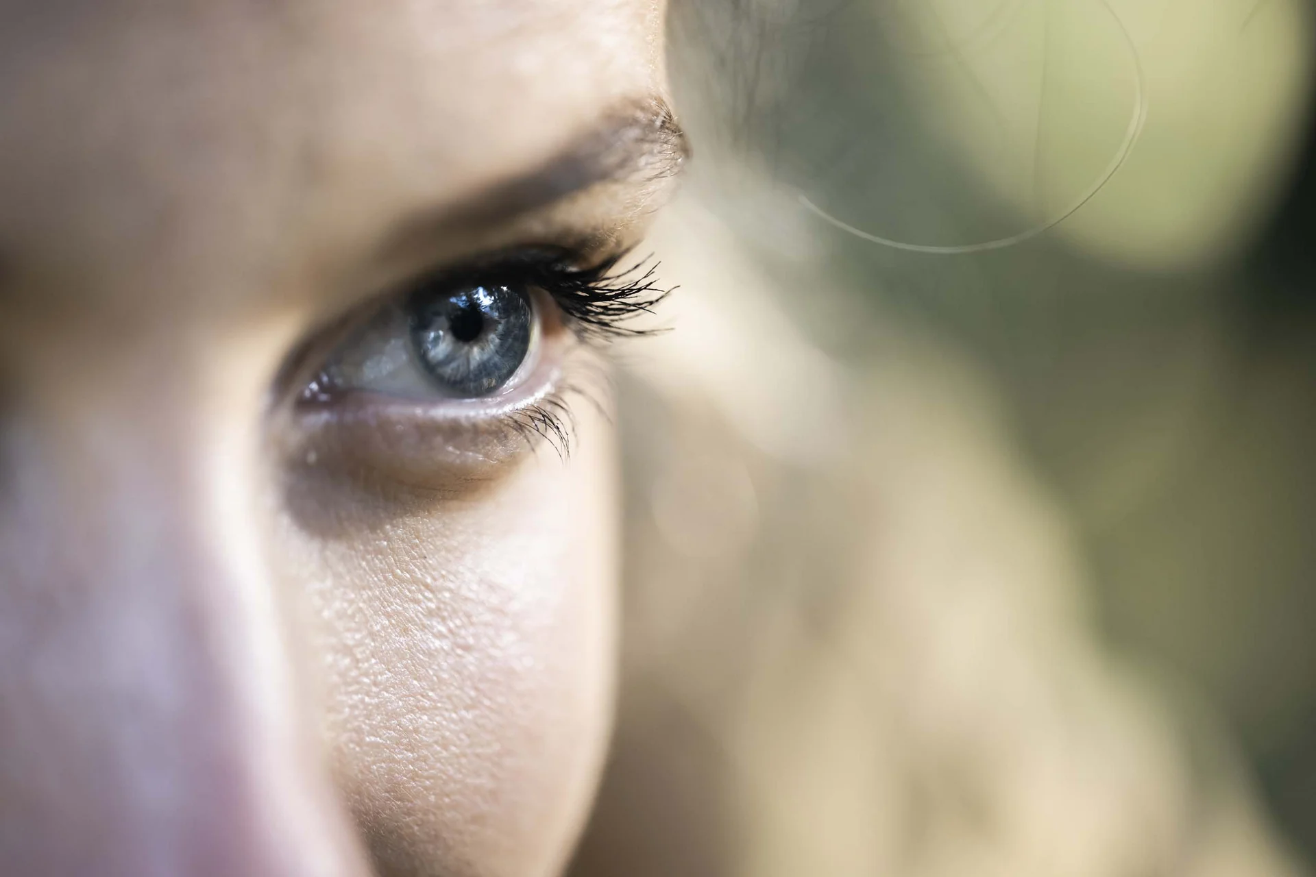 Nahaufnahme eines blauen Auges mit langen Wimpern