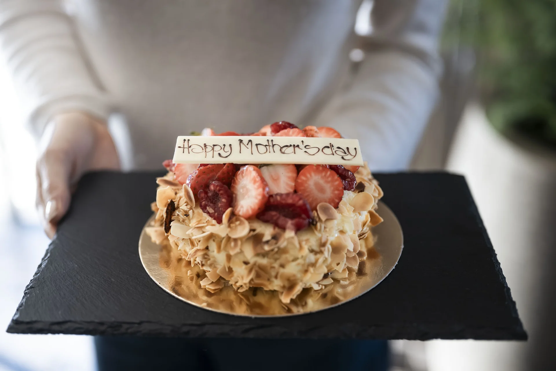 Mother's Day cake with strawberries and almonds on a black slate tray