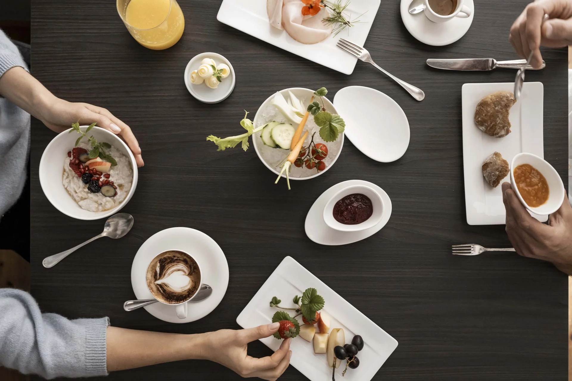 Frühstück mit Obst, Kaffee, Saft und Brot auf einem dunklen Tisch