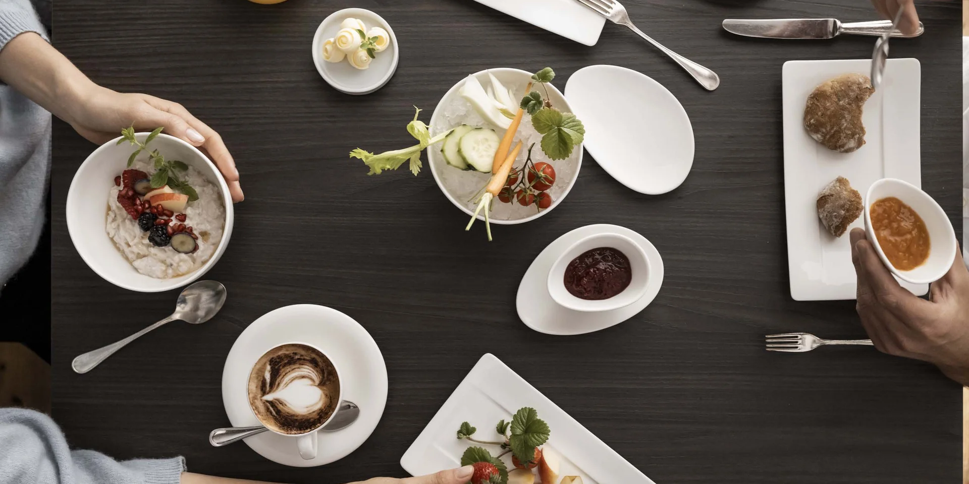 Frühstück mit Obst, Kaffee, Saft und Brot auf einem dunklen Tisch