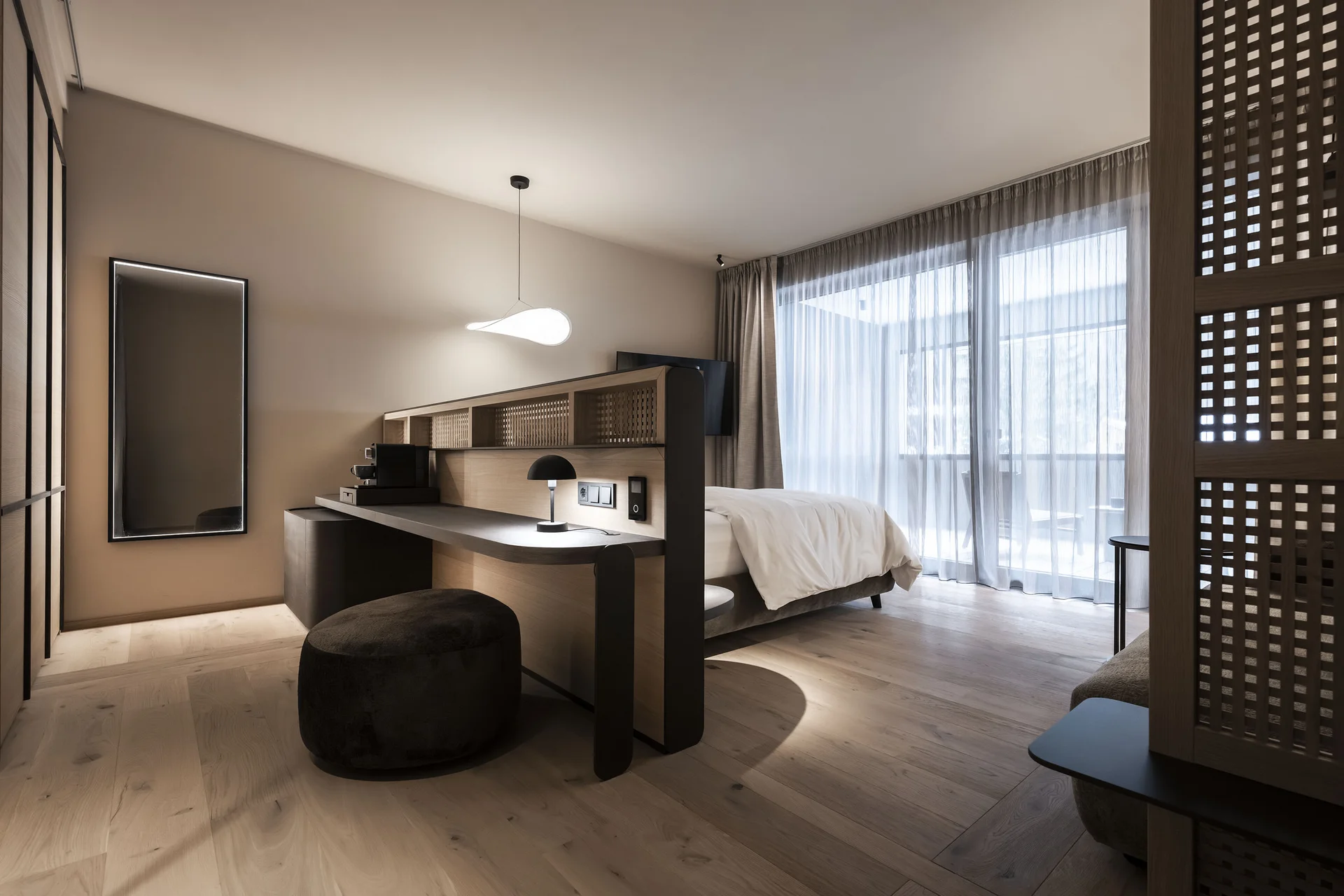 Modernes Hotelzimmer mit Schreibtisch, Bett und großem Fenster