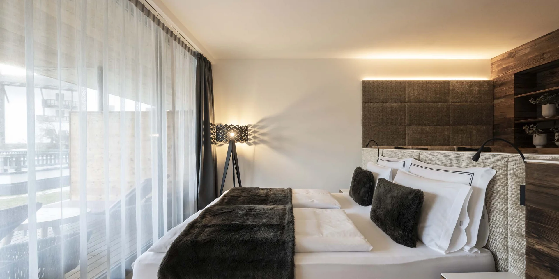 Modernes Schlafzimmer mit großem Bett und bodentiefen Fenstern