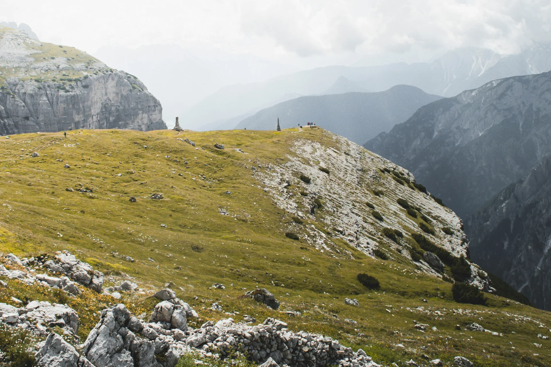 Prateria verde e rocce con cielo nuvoloso nelle Alpi