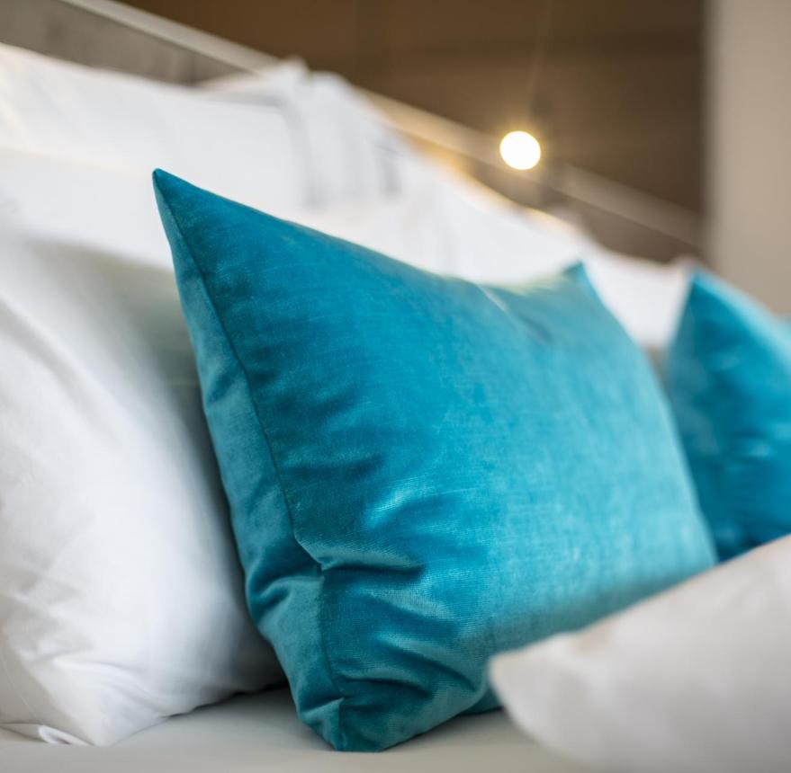 Cuscino blu su letto bianco