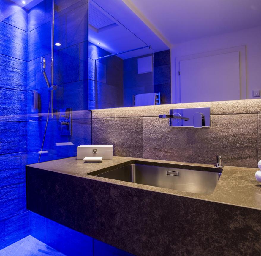 Badezimmer mit Dusche, farbiger LED-Beleuchtung und Waschtisch - Zimmer berg.tal