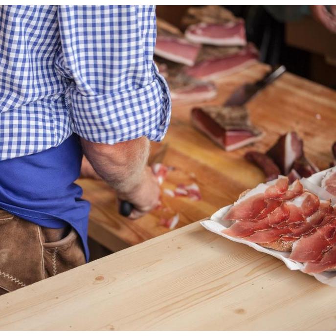 A man is slicing some bacon